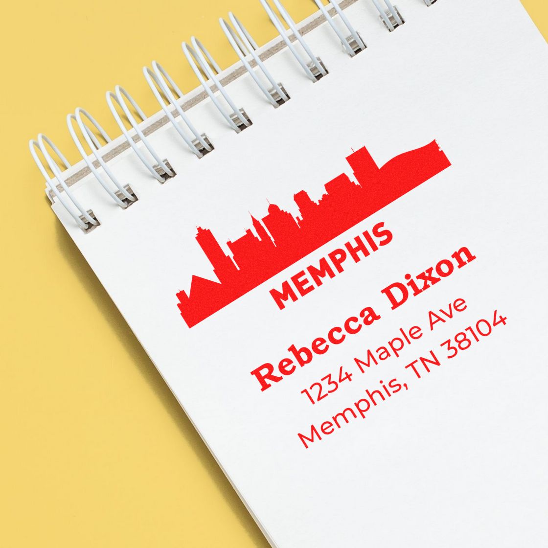 Custom rubber address stamp with Memphis skyline, Rebecca Dixon name, and Tennessee mailing address on notebook.