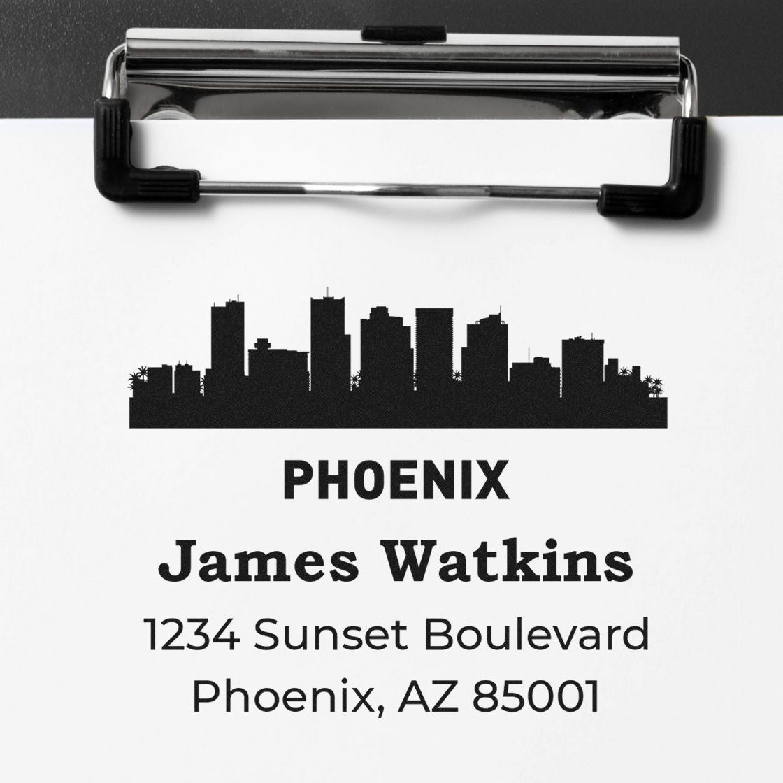 Personalized custom address rubber stamp imprint showing Phoenix skyline, James Watkins, and return address on clipboard.