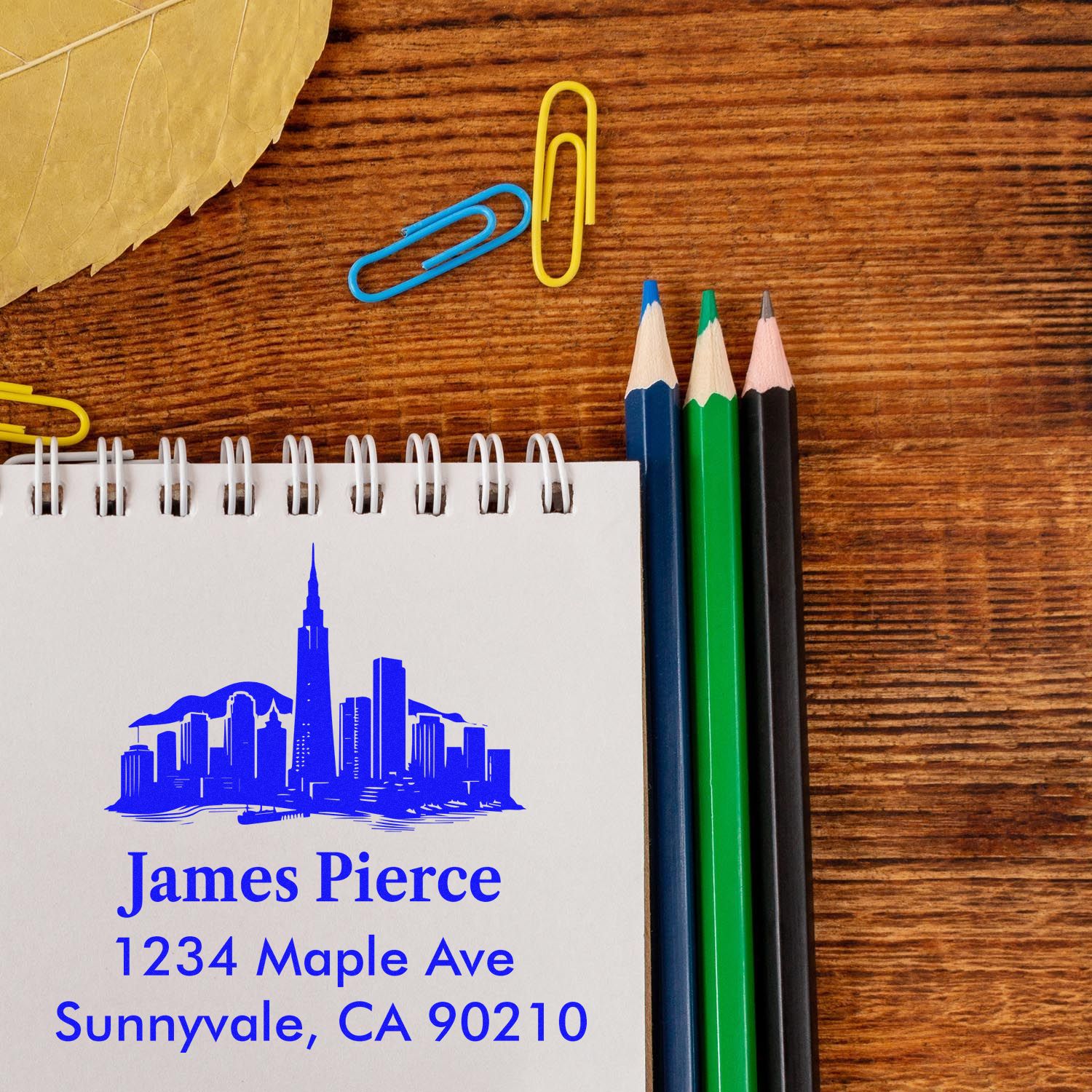 Personalized return address rubber stamp with skyline logo, stamped on a notepad for James Pierce, Sunnyvale CA.