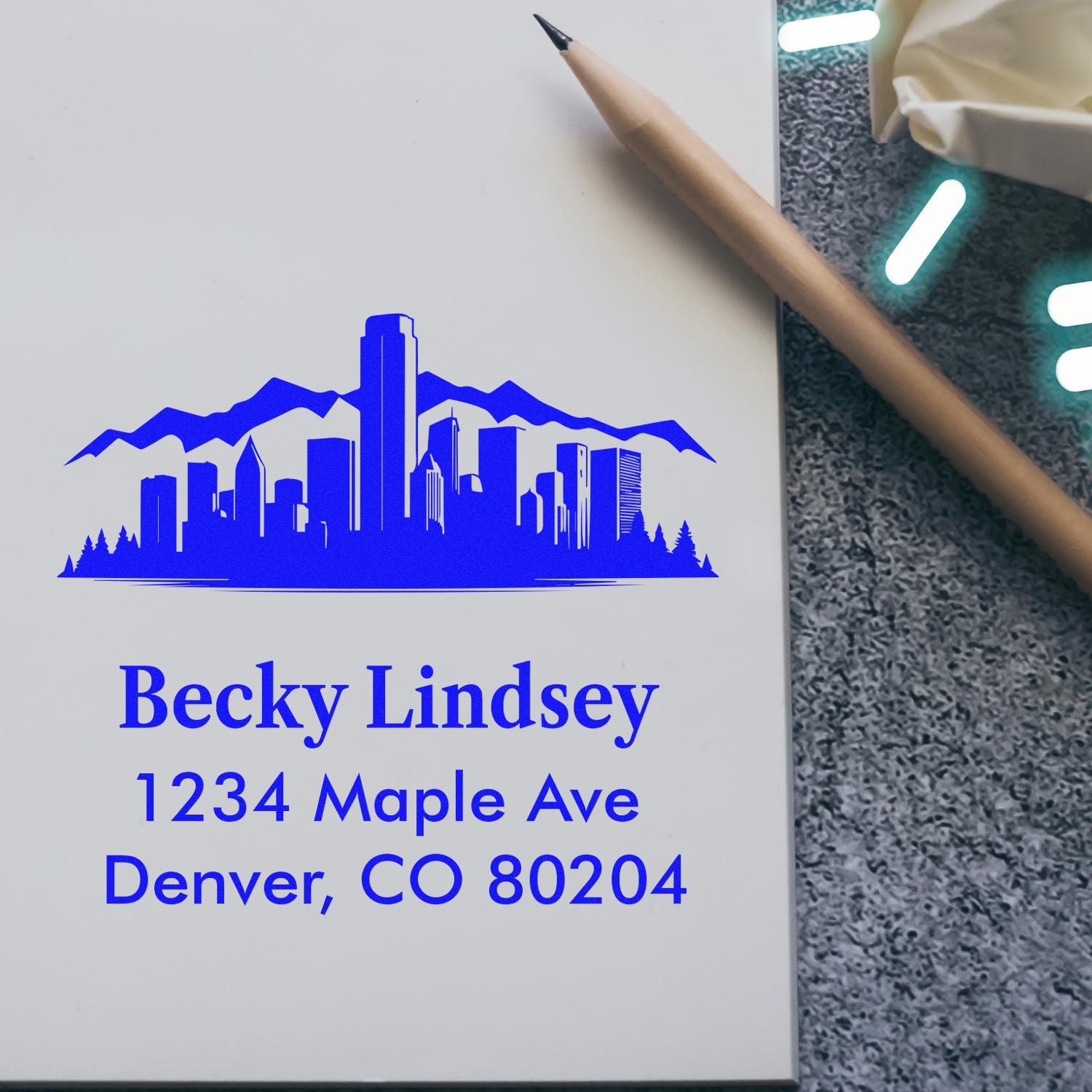 Custom self-inking address stamp with Denver skyline for Becky Lindsey, ideal for personalized mail and packaging.