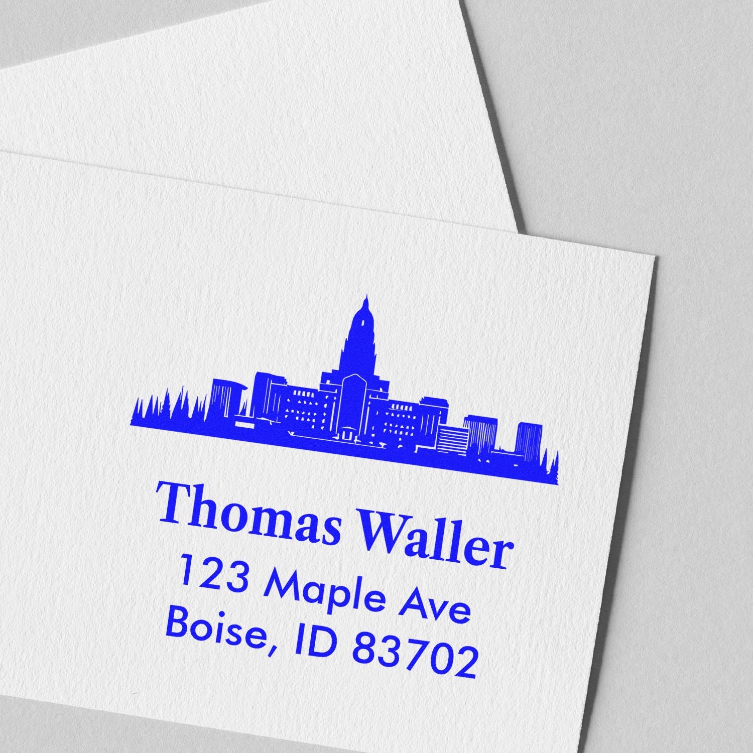 Custom rubber address stamp with Boise skyline logo and Thomas Waller return address in blue ink.