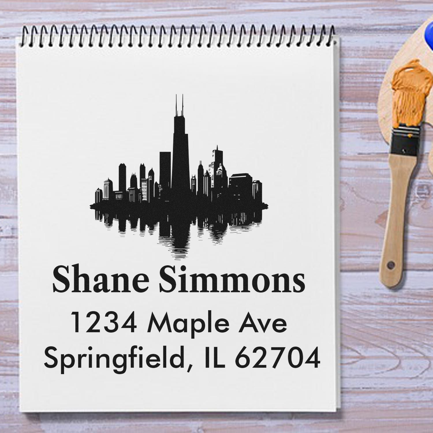 Personalized return address rubber stamp with skyline design, featuring Shane Simmons and Springfield, IL 62704.