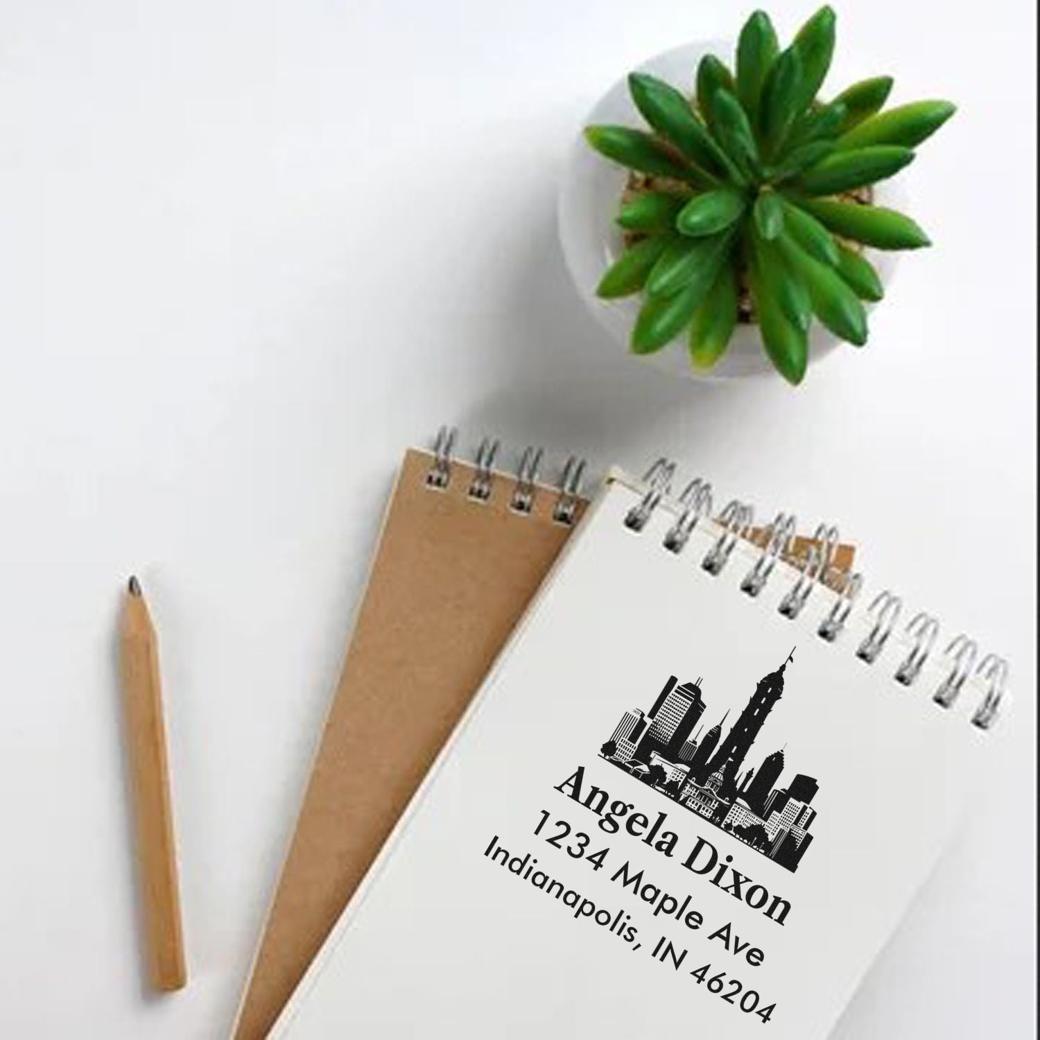 Personalized address rubber stamp with skyline design on notebook, showing name, street address, and ZIP code.