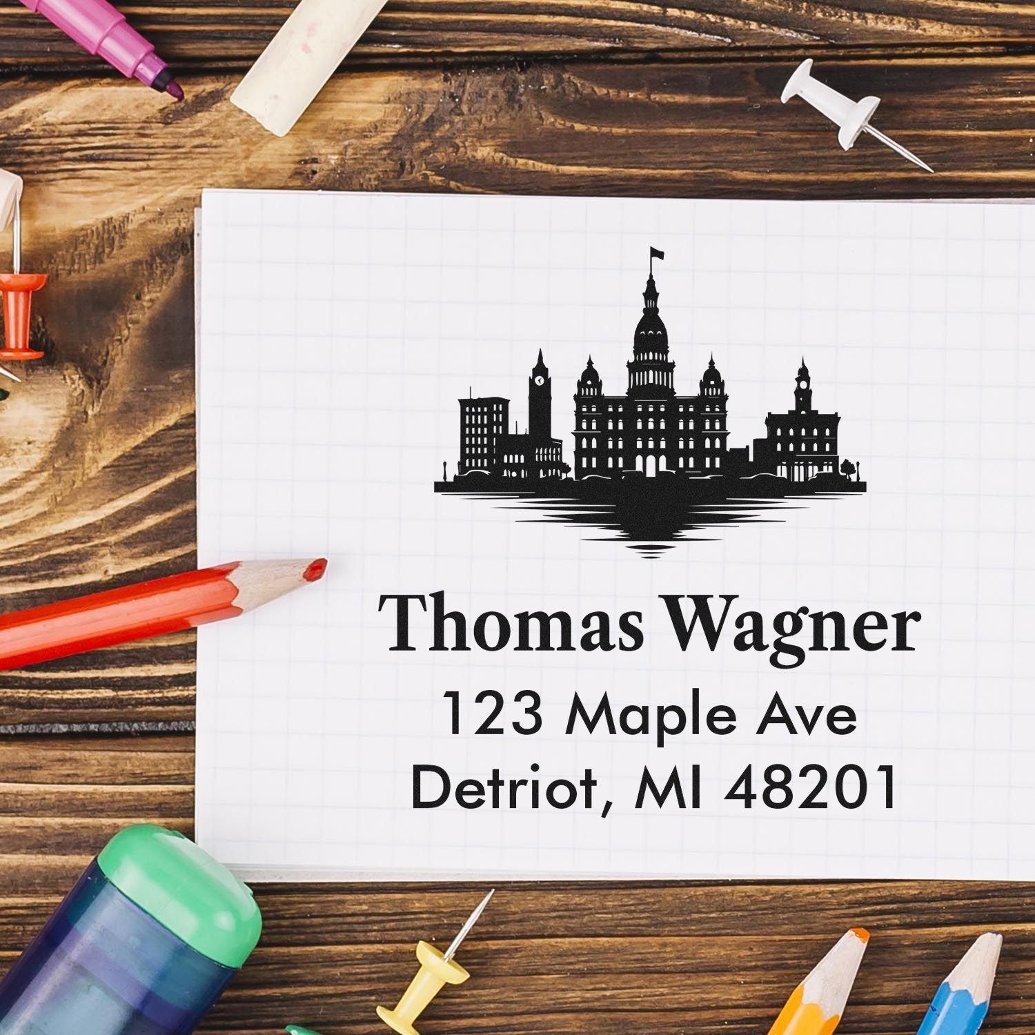 Custom return address rubber stamp with city skyline design for Thomas Wagner, 123 Maple Ave, Detroit, MI 48201.