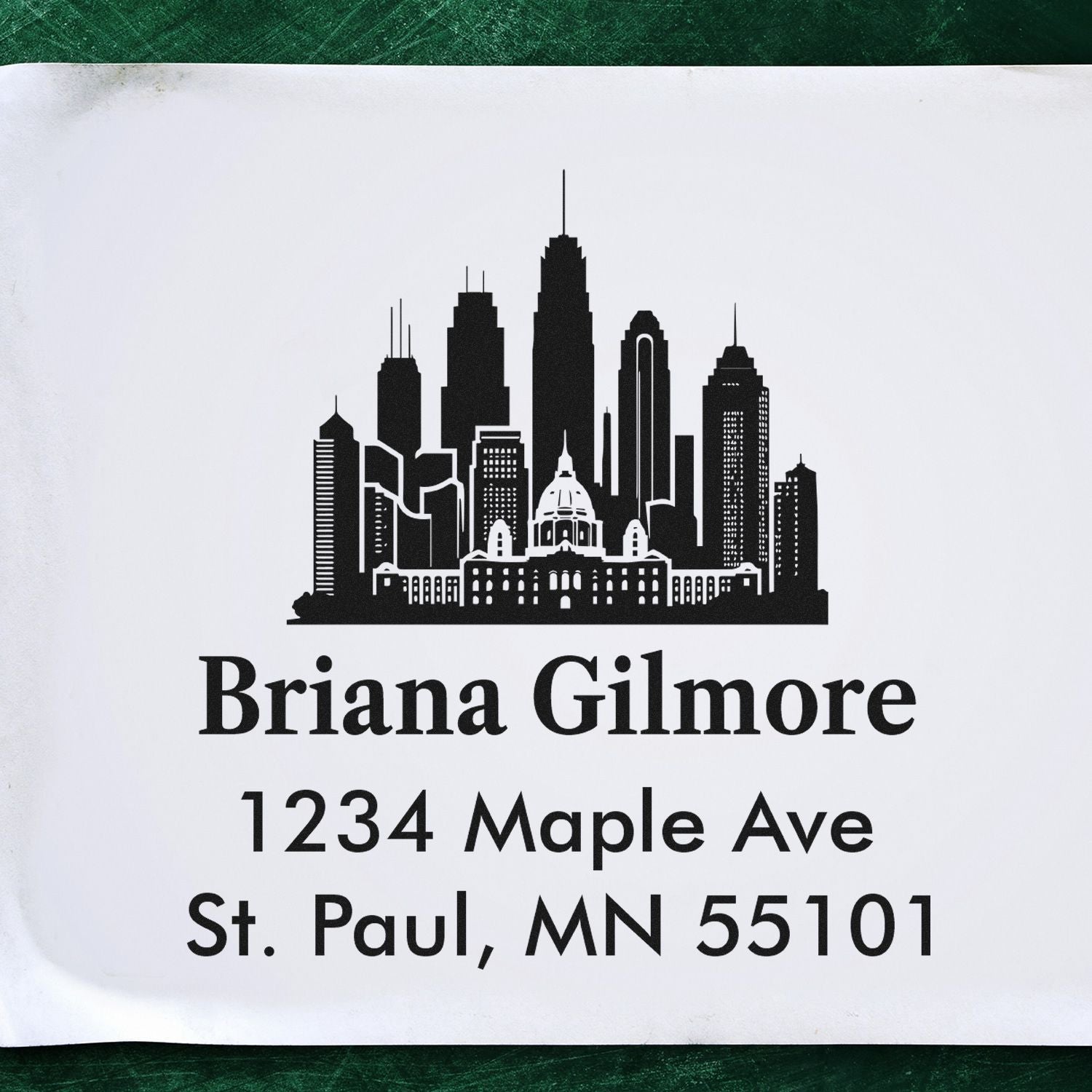 Custom rubber address stamp with city skyline, Briana Gilmore name, and St. Paul, MN 55101 return address.