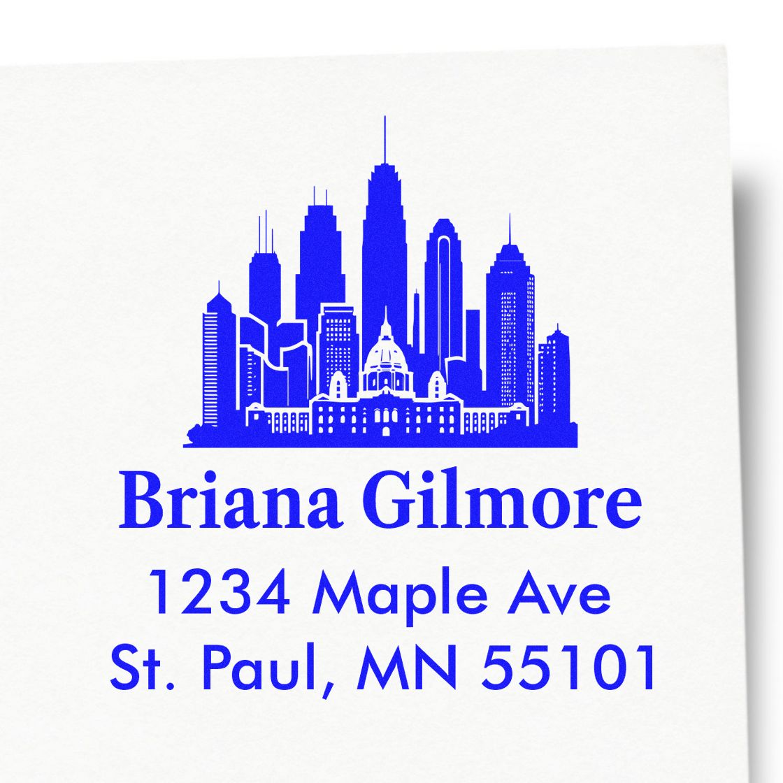 Custom return address rubber stamp with city skyline for Briana Gilmore, 1234 Maple Ave, St. Paul, MN 55101.