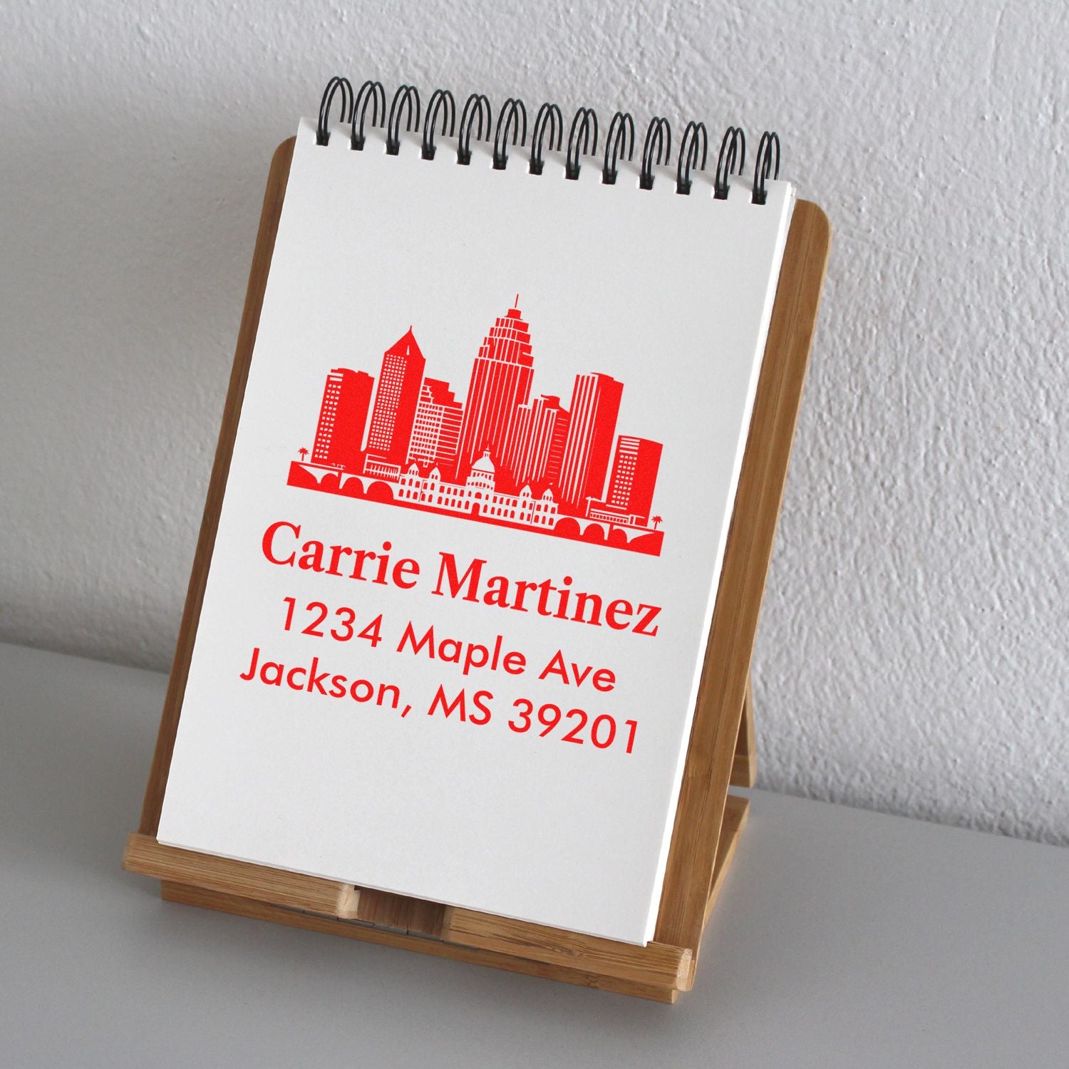 Custom return address rubber stamp with skyline design, red ink, and personalized name and Jackson, MS address.