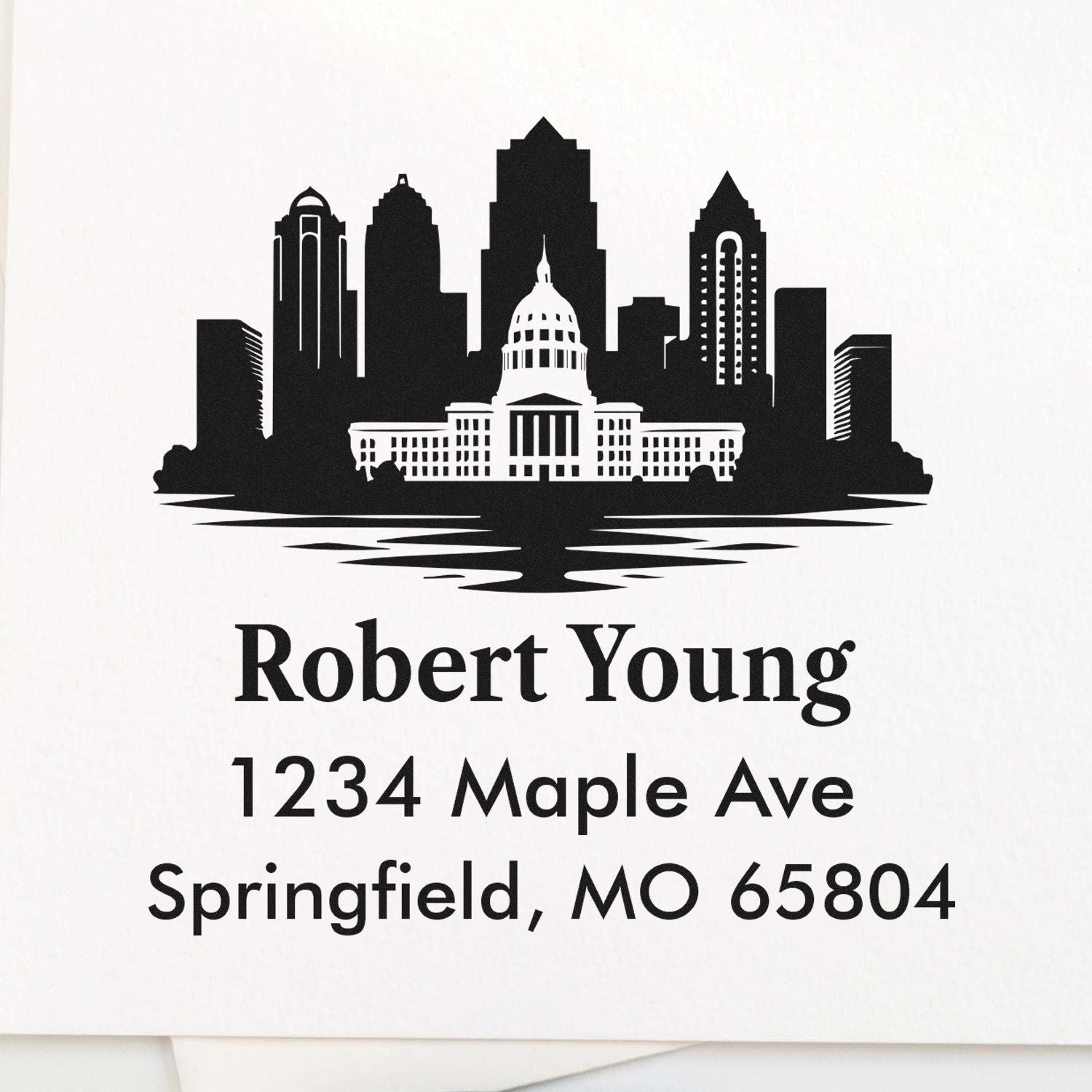 Custom return address rubber stamp for Robert Young, Springfield, MO 65804, featuring a city skyline and capitol design.