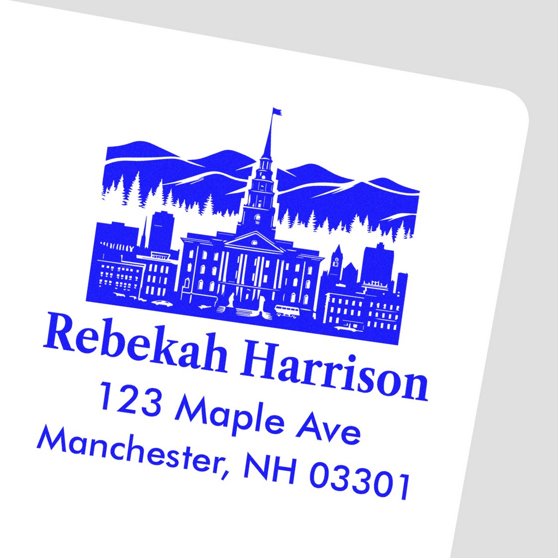 Custom return address rubber stamp with city skyline for Rebekah Harrison, 123 Maple Ave, Manchester, NH 03301.