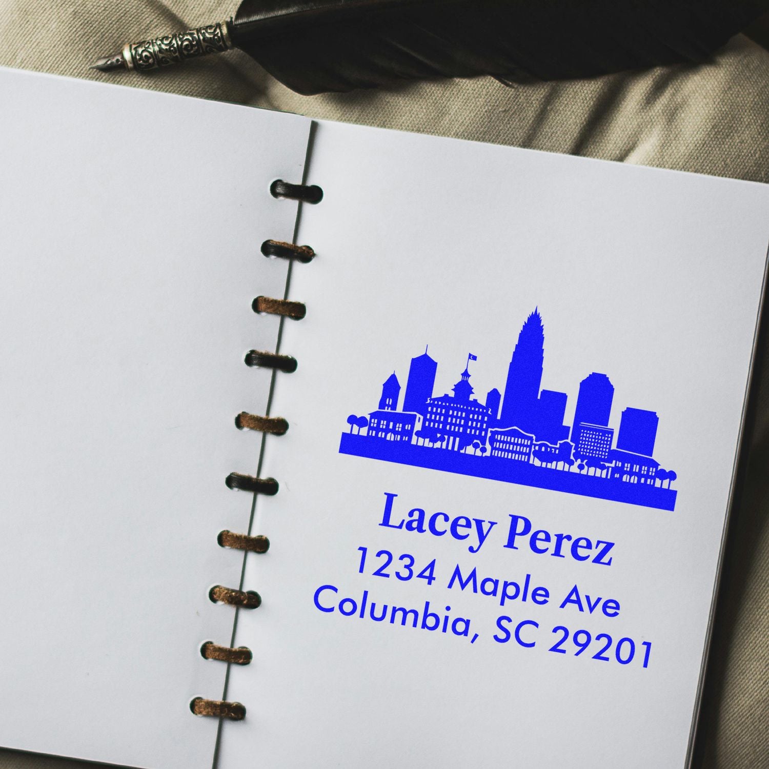 Custom return address rubber stamp with Columbia, SC skyline and Lacey Perez address imprint on notebook page.
