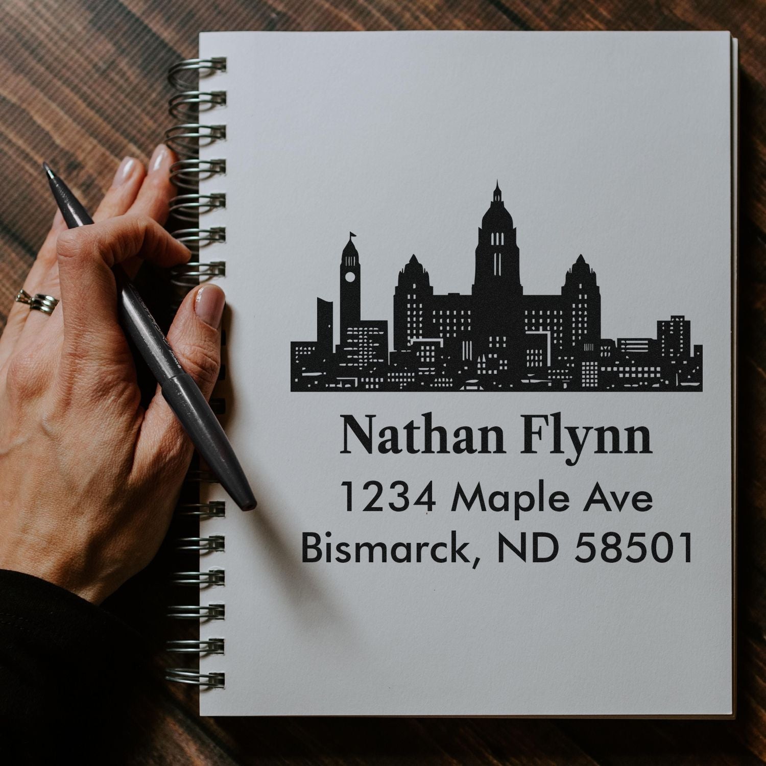 Personalized return address rubber stamp with Bismarck skyline for Nathan Flynn, 1234 Maple Ave, Bismarck, ND 58501.