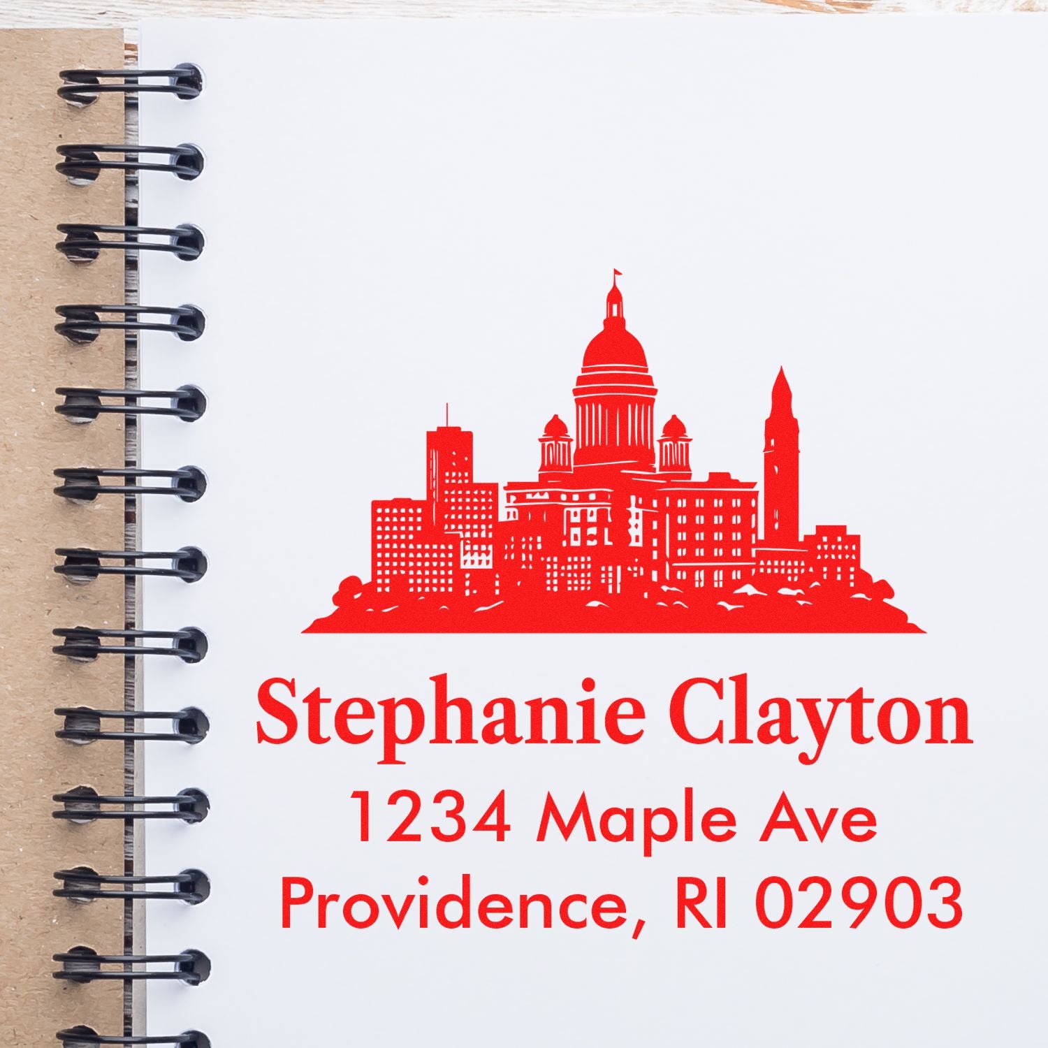 Custom address rubber stamp with red city skyline for Stephanie Clayton, 1234 Maple Ave, Providence, RI 02903.
