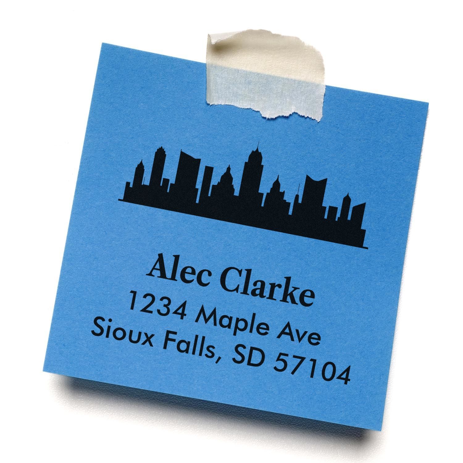 Custom address rubber stamp with skyline logo for Alec Clarke, 1234 Maple Ave, Sioux Falls, SD 57104.