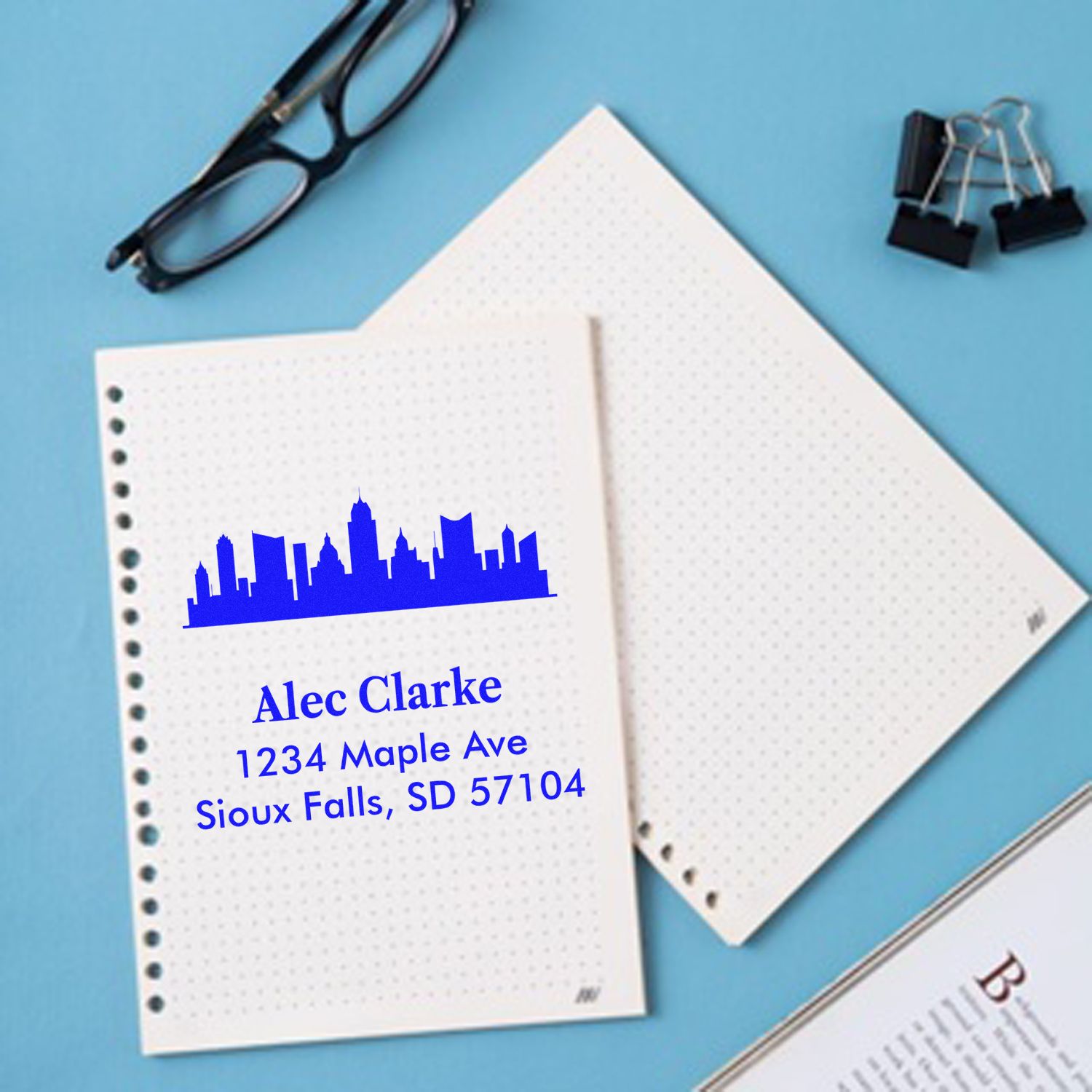 Custom skyline return address rubber stamp on stationery with personalized name and mailing address.