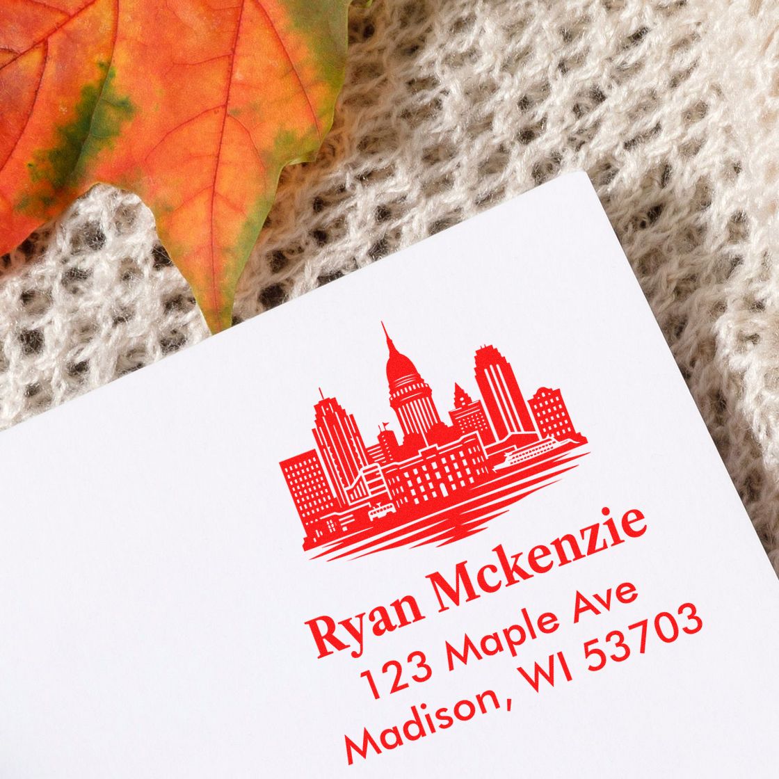 Custom return address rubber stamp with city skyline logo for Ryan McKenzie, 123 Maple Ave, Madison, WI 53703.