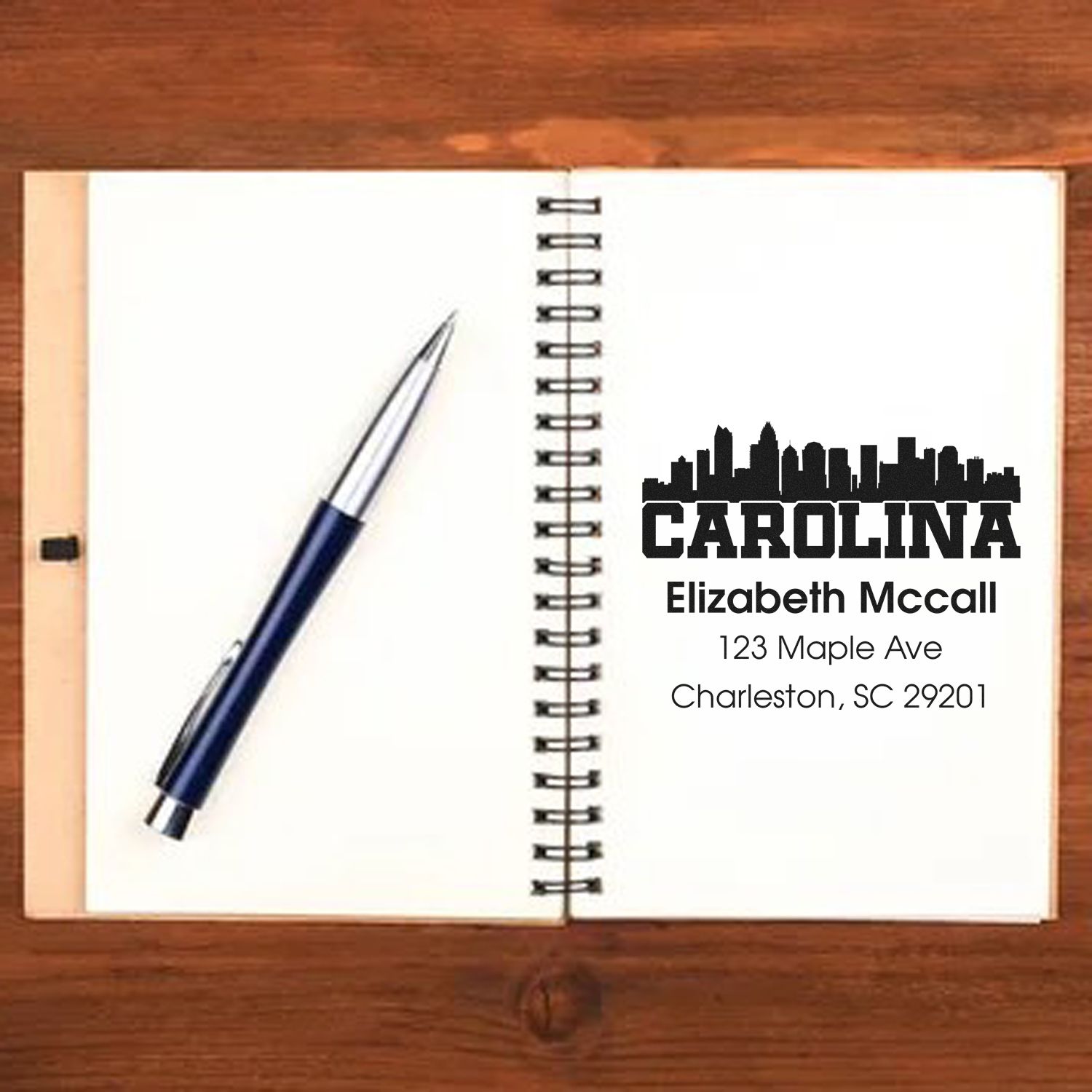 Custom Carolina address rubber stamp imprint with skyline logo, name, and Charleston, SC address on notebook.