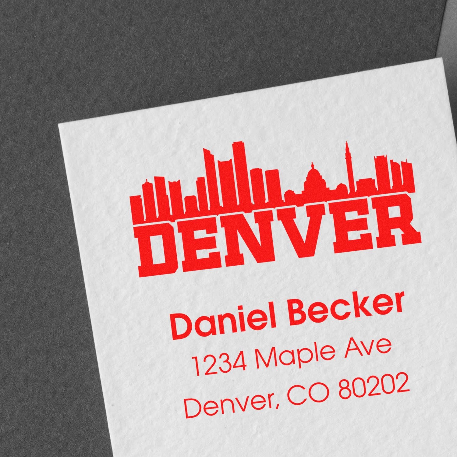 Custom Denver rubber stamp with skyline, name, and return address on white paper