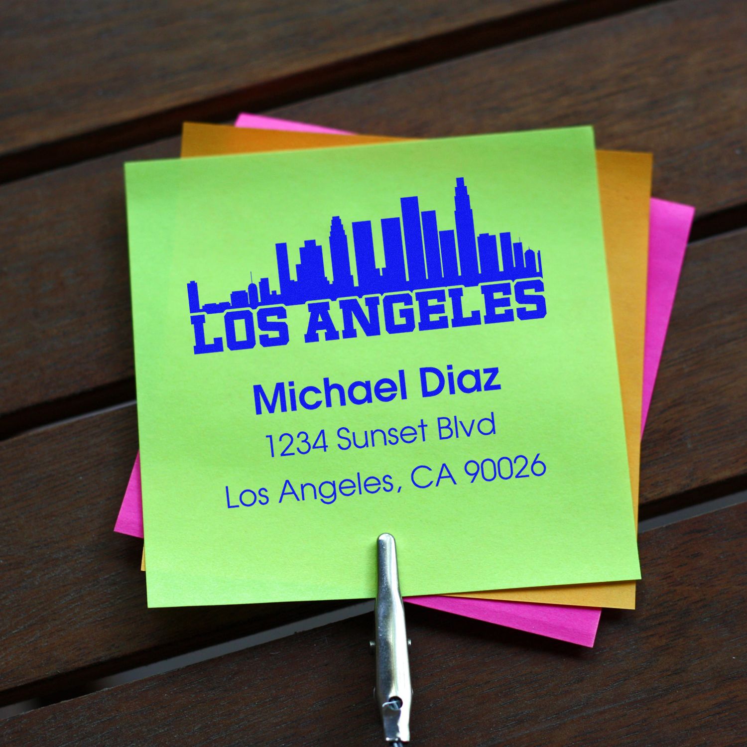 Personalized rubber address stamp with Los Angeles skyline, name, and mailing address on colorful sticky notes.