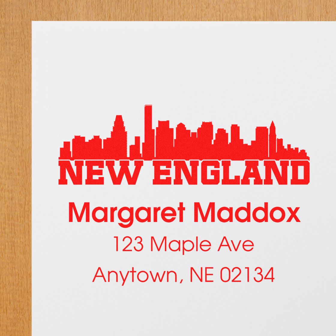 Custom New England rubber stamp with skyline and return address for Margaret Maddox, 123 Maple Ave, Anytown, NE 02134.