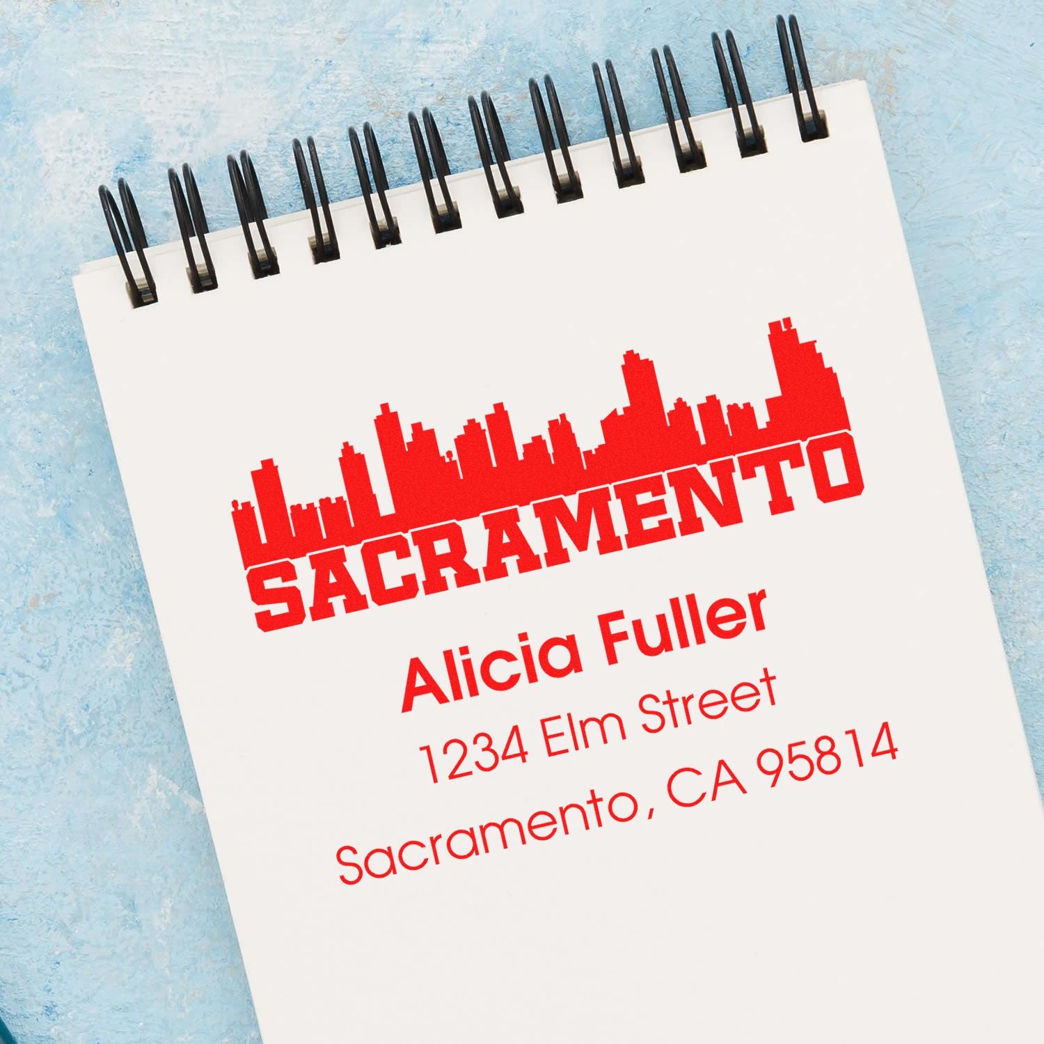 Custom rubber address stamp with Sacramento skyline, featuring Alicia Fuller, 1234 Elm Street, Sacramento, CA 95814.
