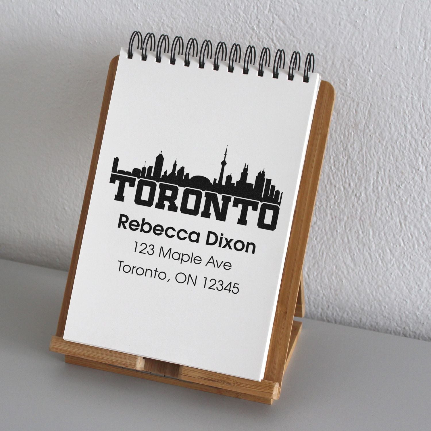 Personalized Toronto address rubber stamp with skyline design for Rebecca Dixon, 123 Maple Ave, Toronto, ON.