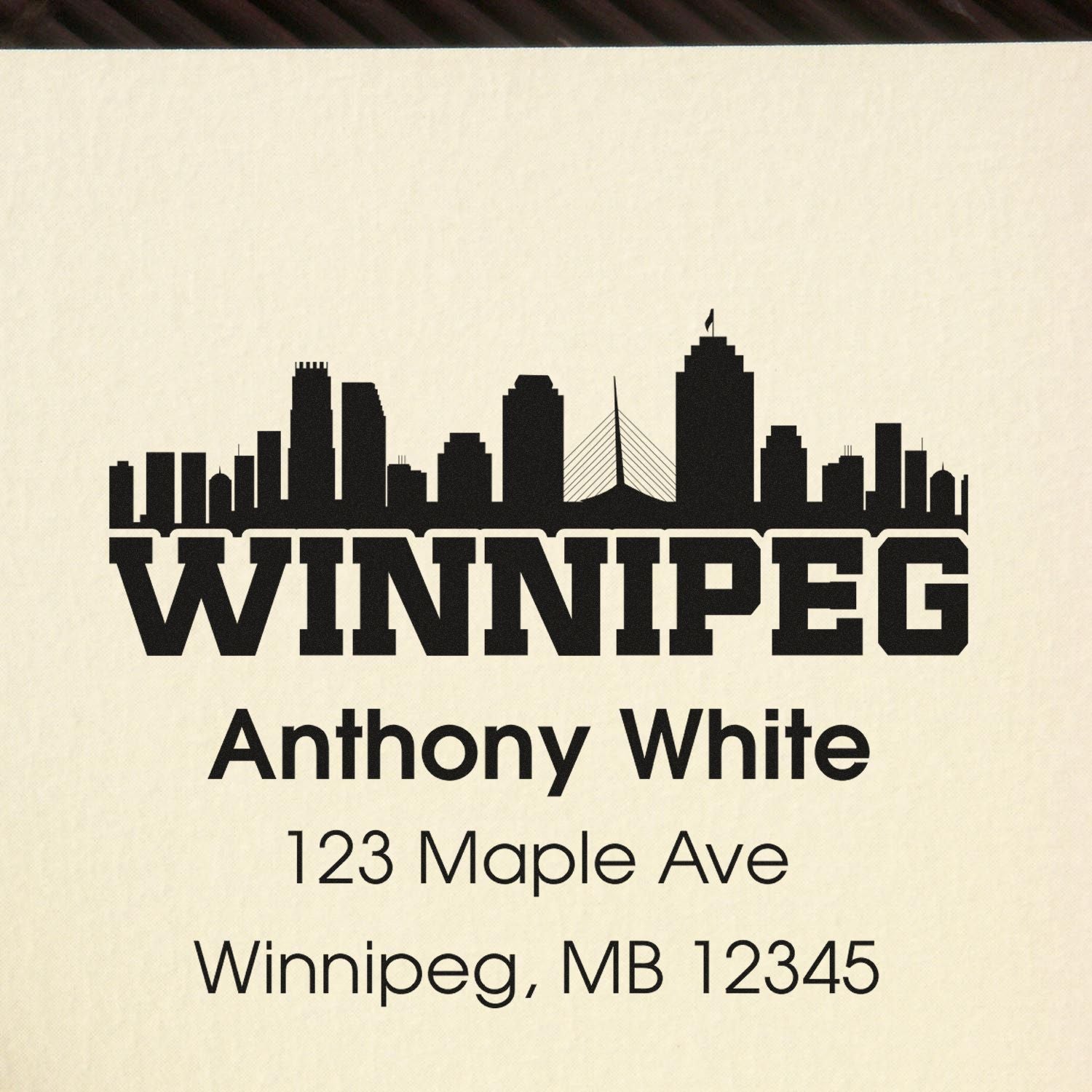 Custom Winnipeg return address rubber stamp with skyline, Anthony White, 123 Maple Ave, Winnipeg, MB 12345.