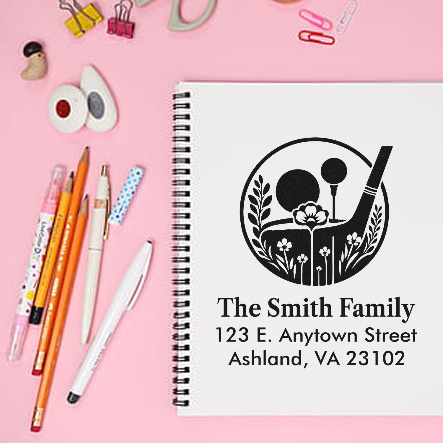 Personalized return address rubber stamp with golf-themed floral design, shown on a notebook for The Smith Family.