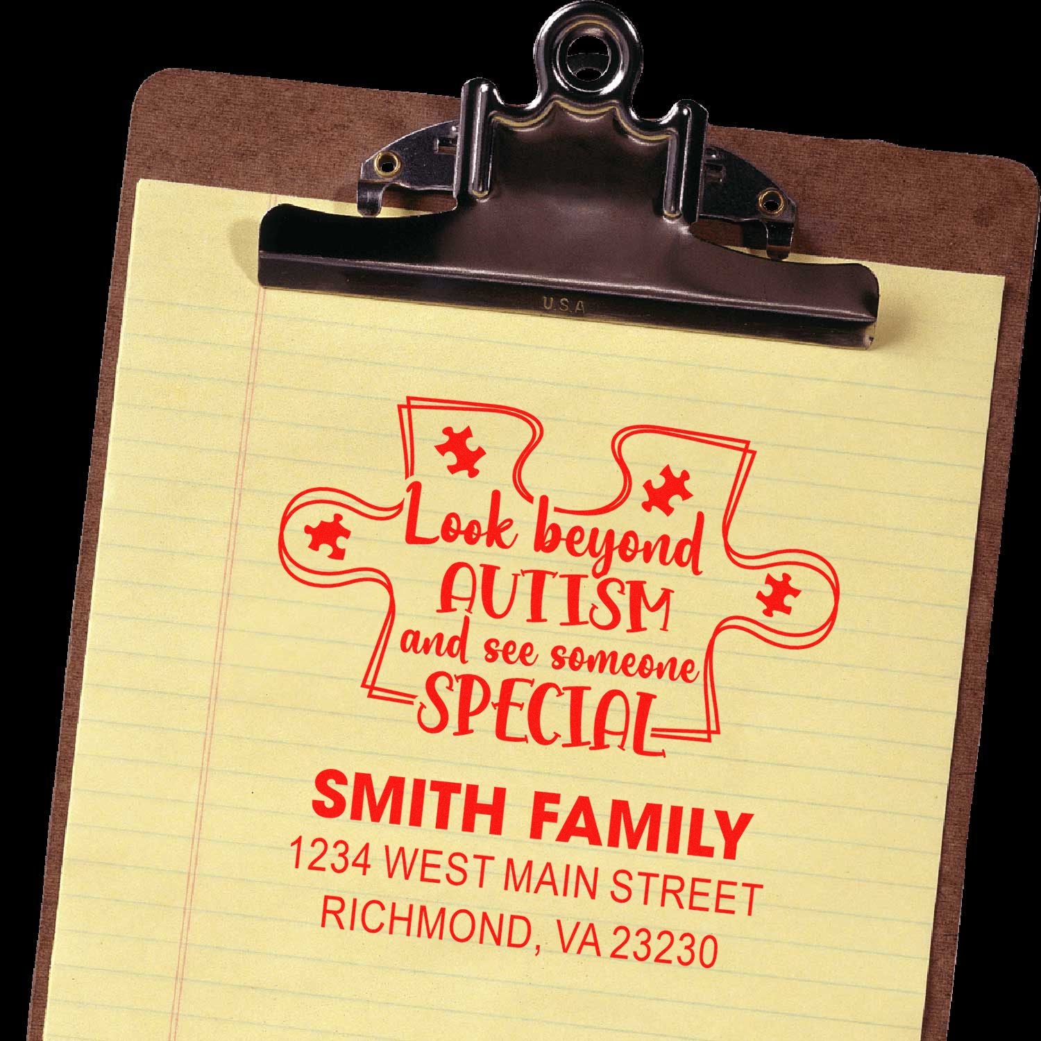 Custom rubber stamp impression with autism awareness message and family return address on a clipboard
