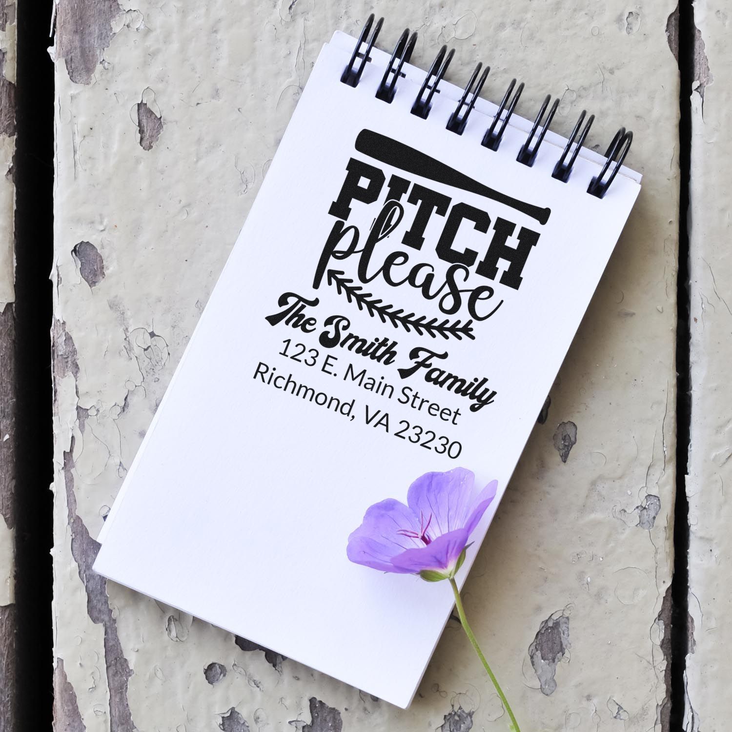 Custom family return address rubber stamp sample with Pitch Please and Smith Family address on a notebook.