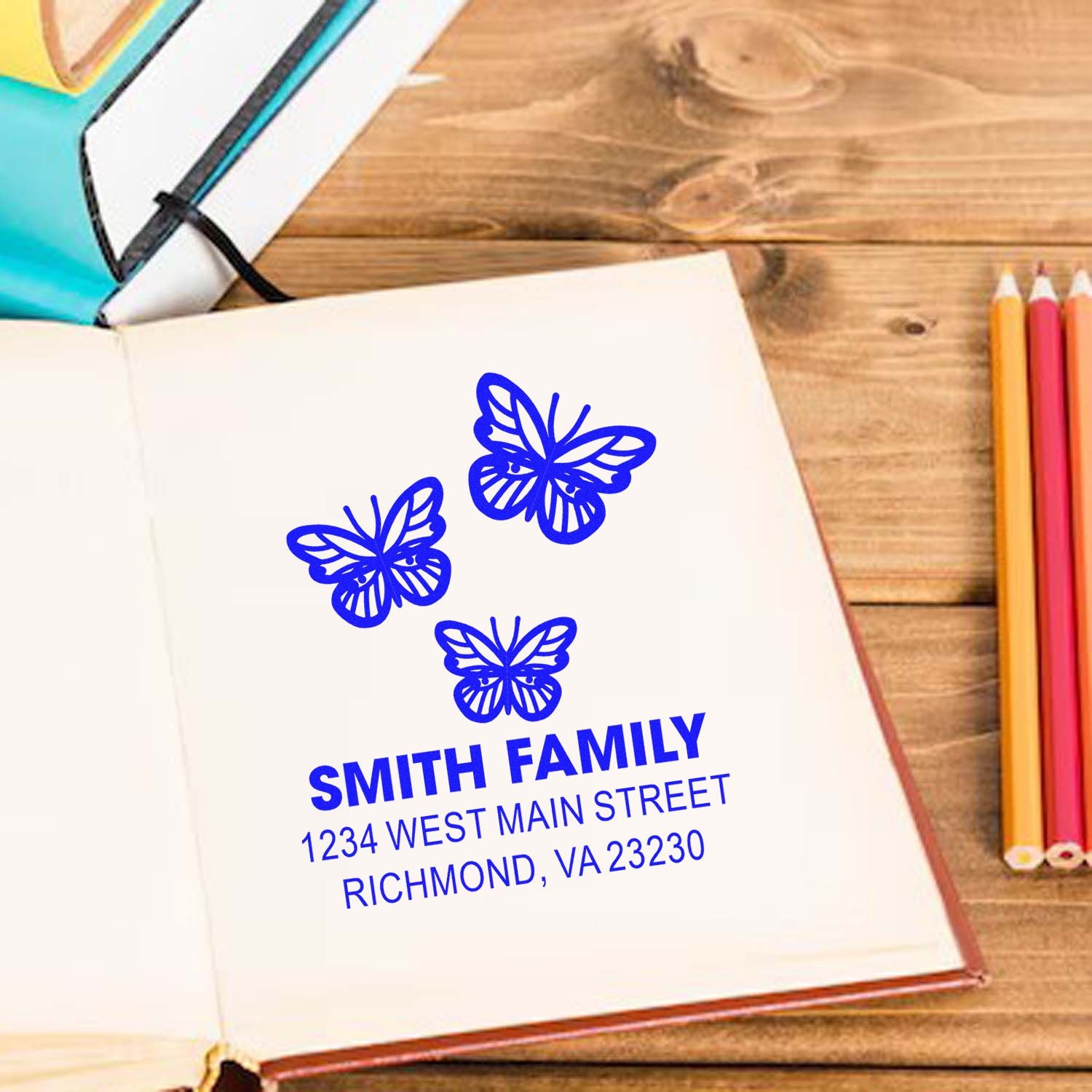 Custom butterfly family address rubber stamp impression on notebook with Smith family name and Richmond, VA address.