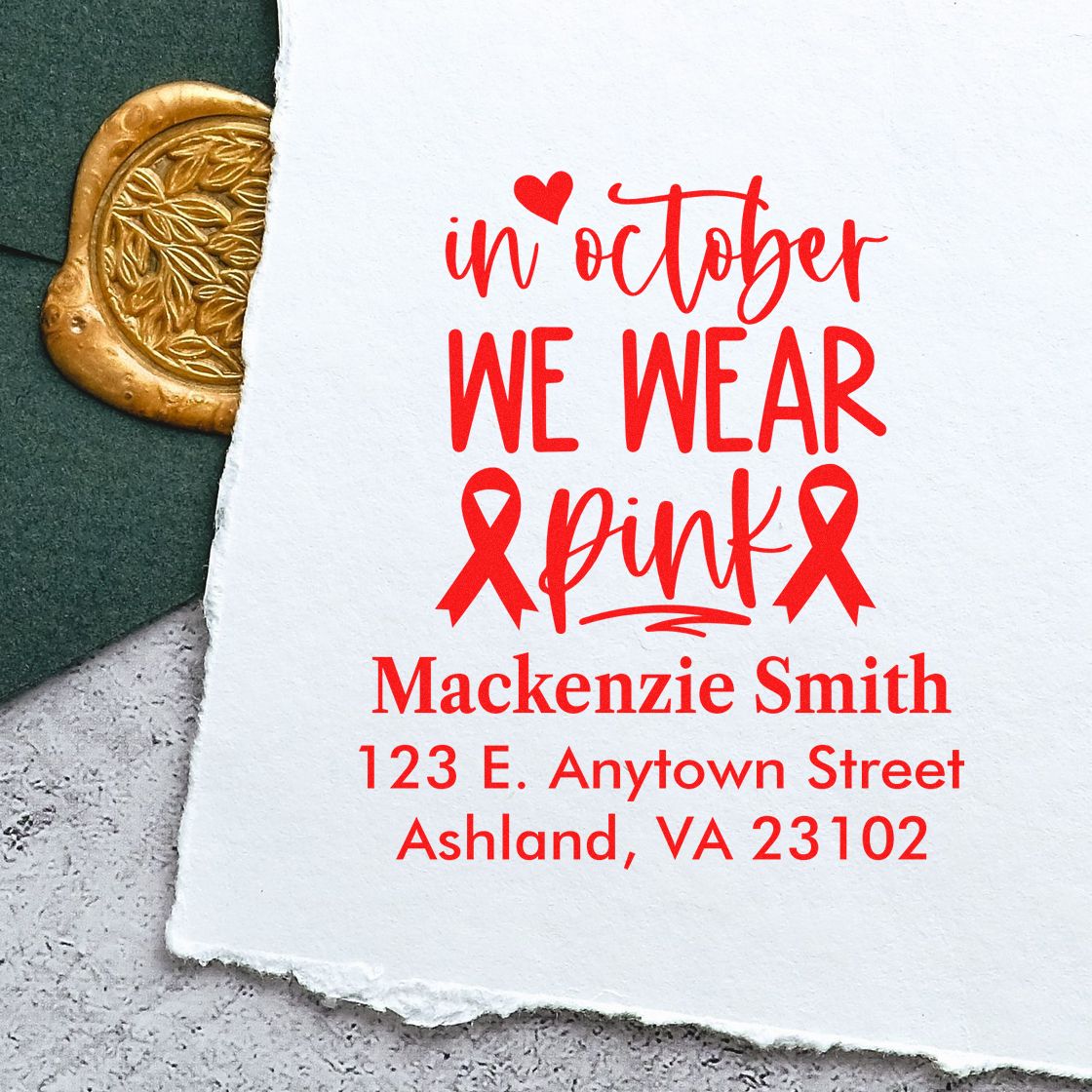 Personalized rubber stamp impression with In October We Wear Pink breast cancer awareness message and address.