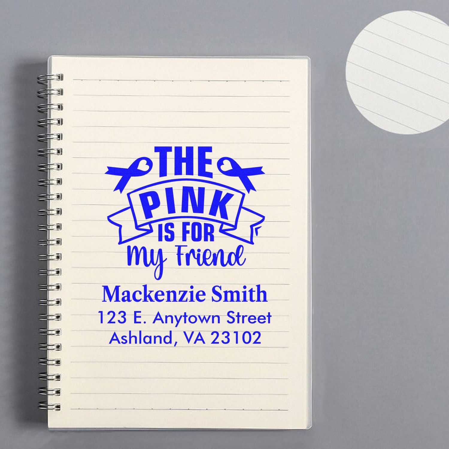Personalized rubber stamp mockup on notebook with The Pink Is for My Friend and custom name and address design.