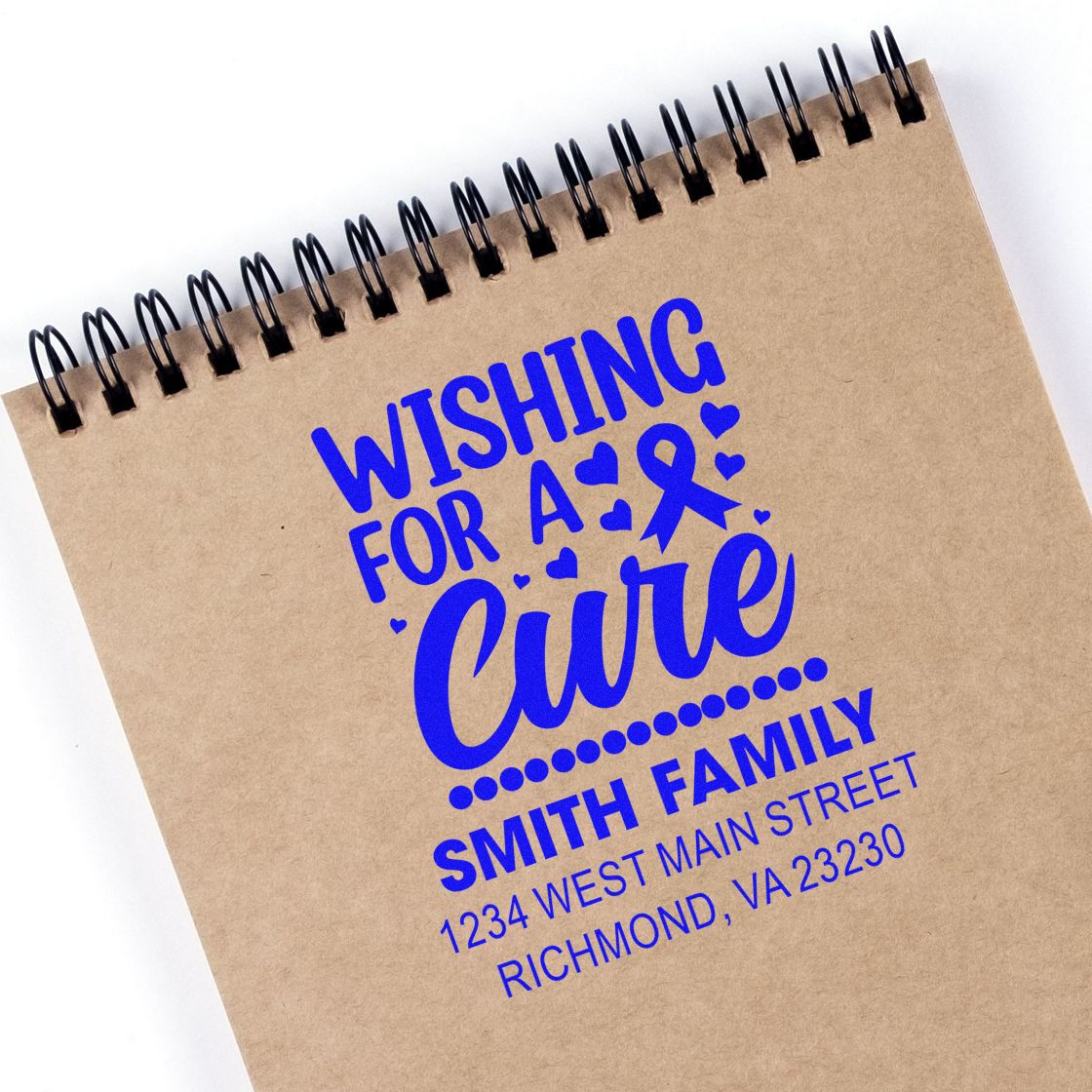 Custom rubber stamp impression for cancer awareness reading Wishing for a Cure with ribbon and Smith Family return address.