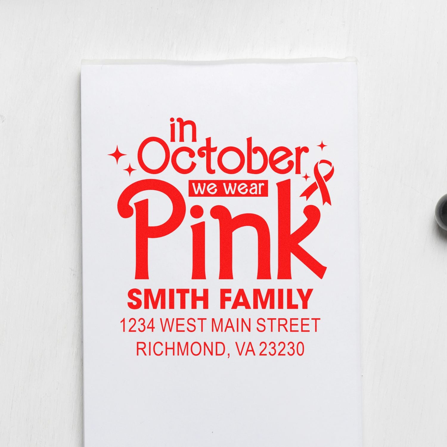 Custom breast cancer awareness rubber stamp with In October We Wear Pink message, pink ribbon, and Smith Family return address.