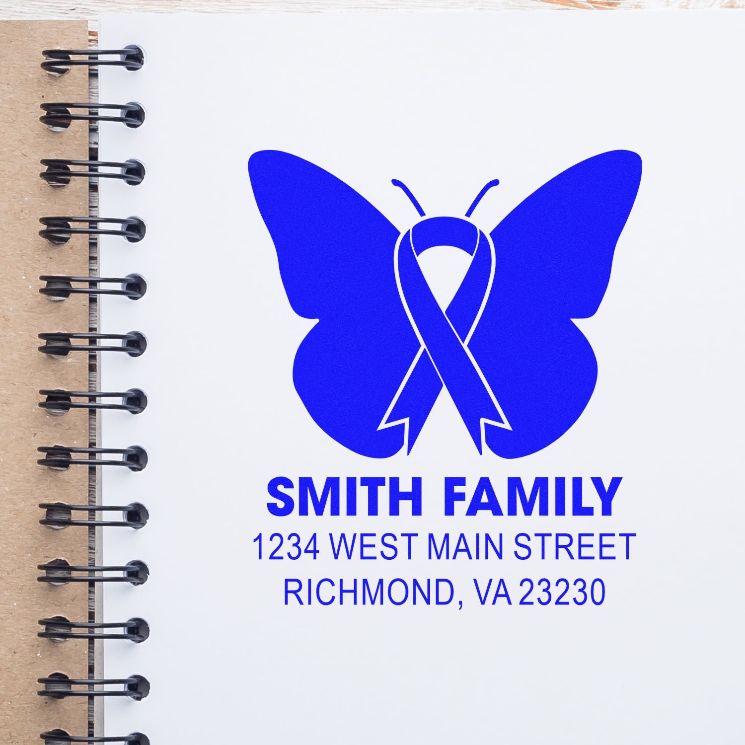 Custom return address rubber stamp with blue butterfly ribbon logo for Smith Family, 1234 West Main Street, Richmond, VA 23230.