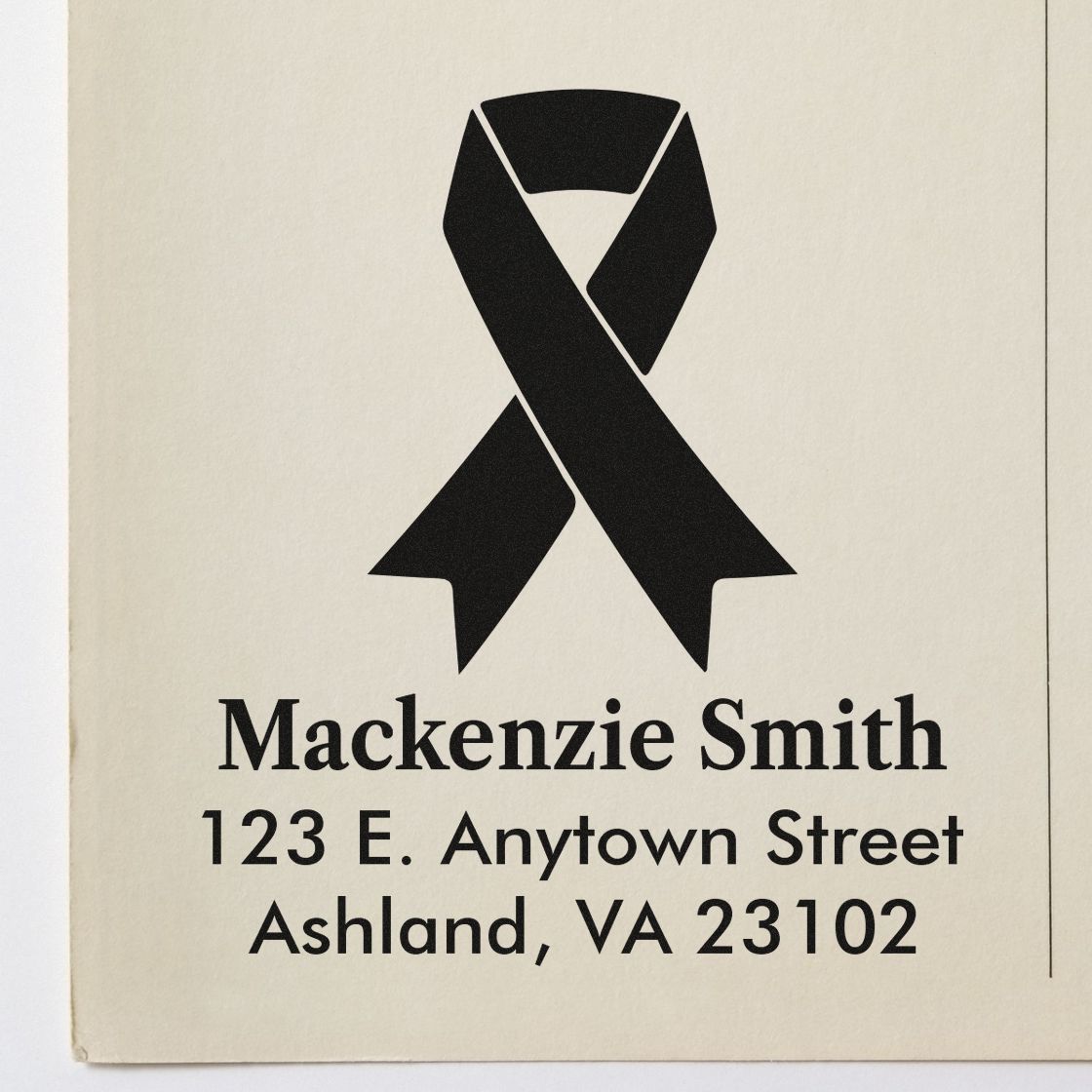 Custom return address rubber stamp with black awareness ribbon, Mackenzie Smith name, and Ashland, VA 23102 mailing details.