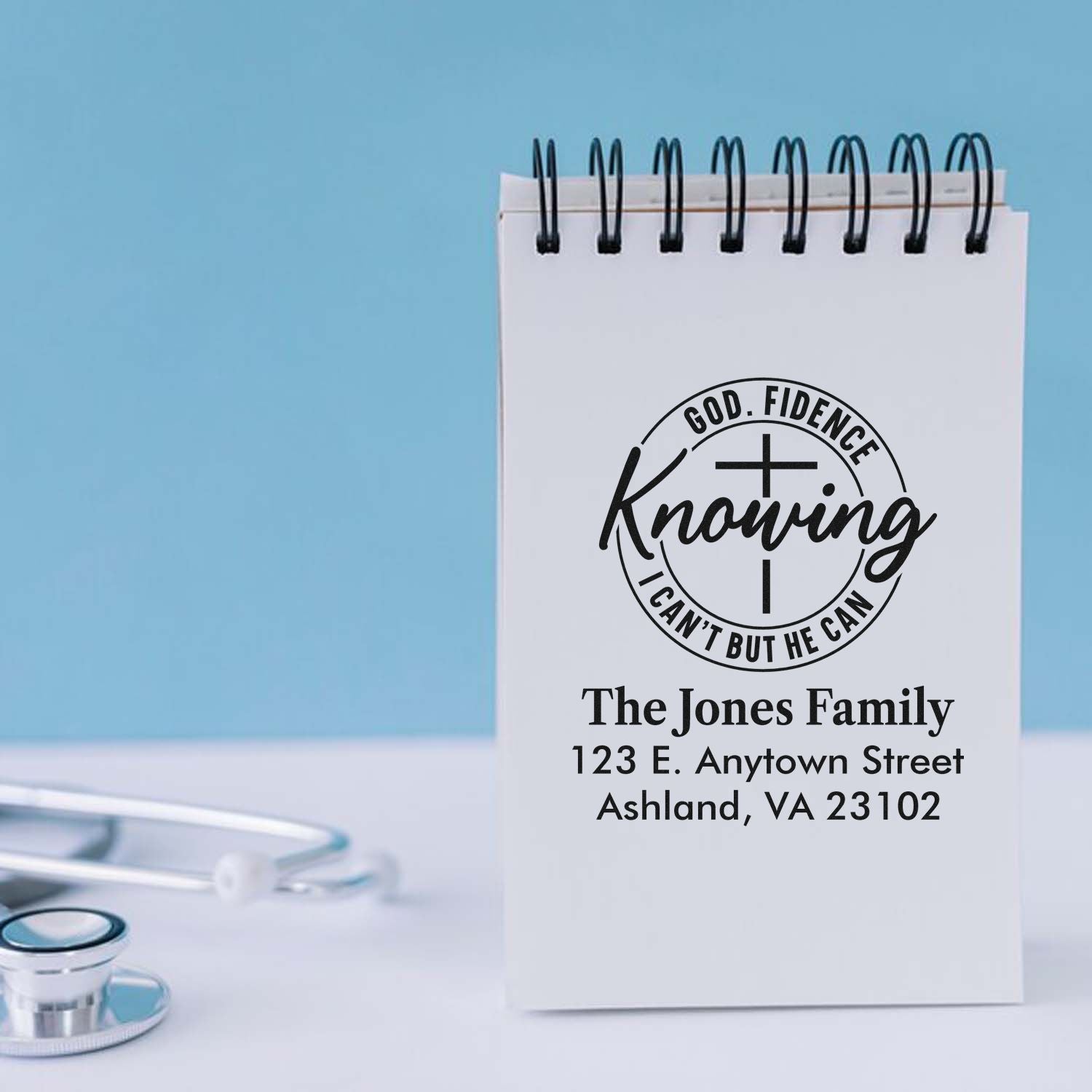 Custom Christian address rubber stamp with Godfidence cross design on a notepad for personalized family mailings.