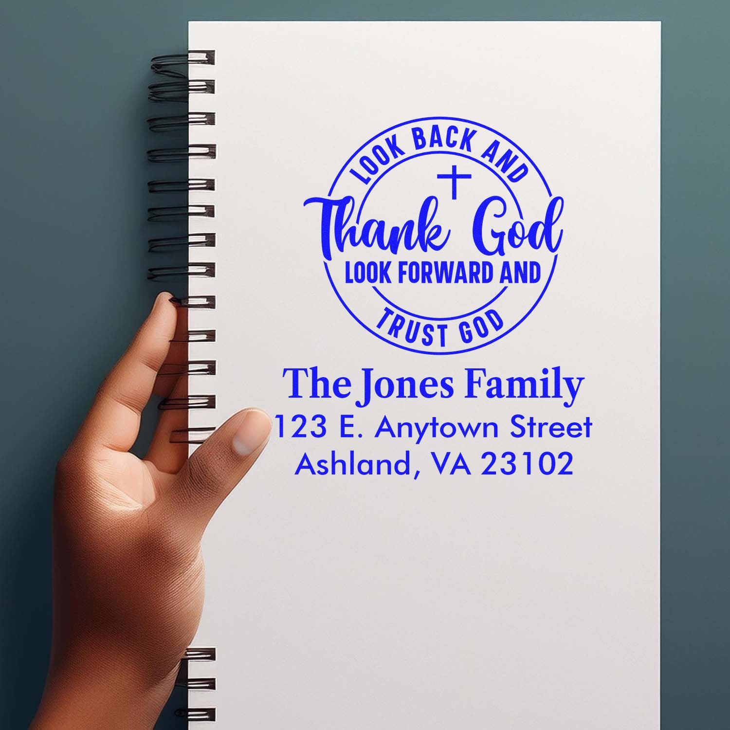 Personalized rubber address stamp with Christian quote for The Jones Family, blue ink on notebook cover.