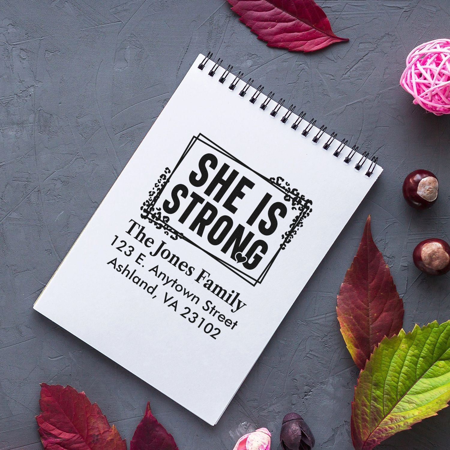 Custom rubber stamp with She Is Strong design and family address for personalized mail, cards, and packaging.