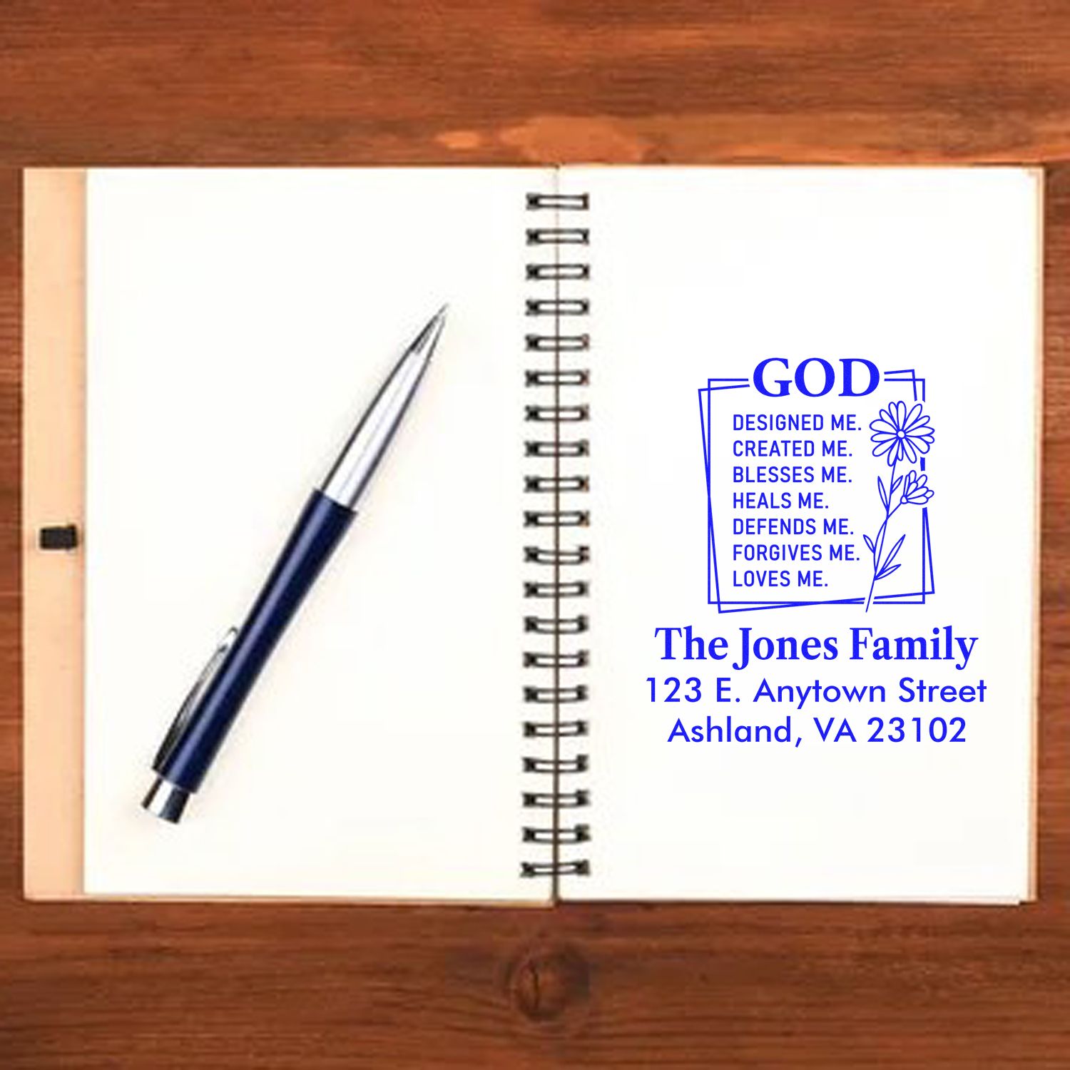 Faith-based custom rubber stamp with family name and address, shown in a notebook for personalized return address use.