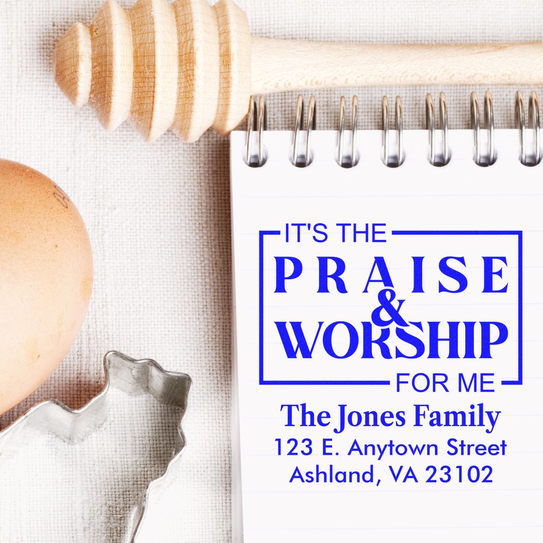 Faith-themed custom rubber stamp with Praise & Worship and personalized family address on a notebook.