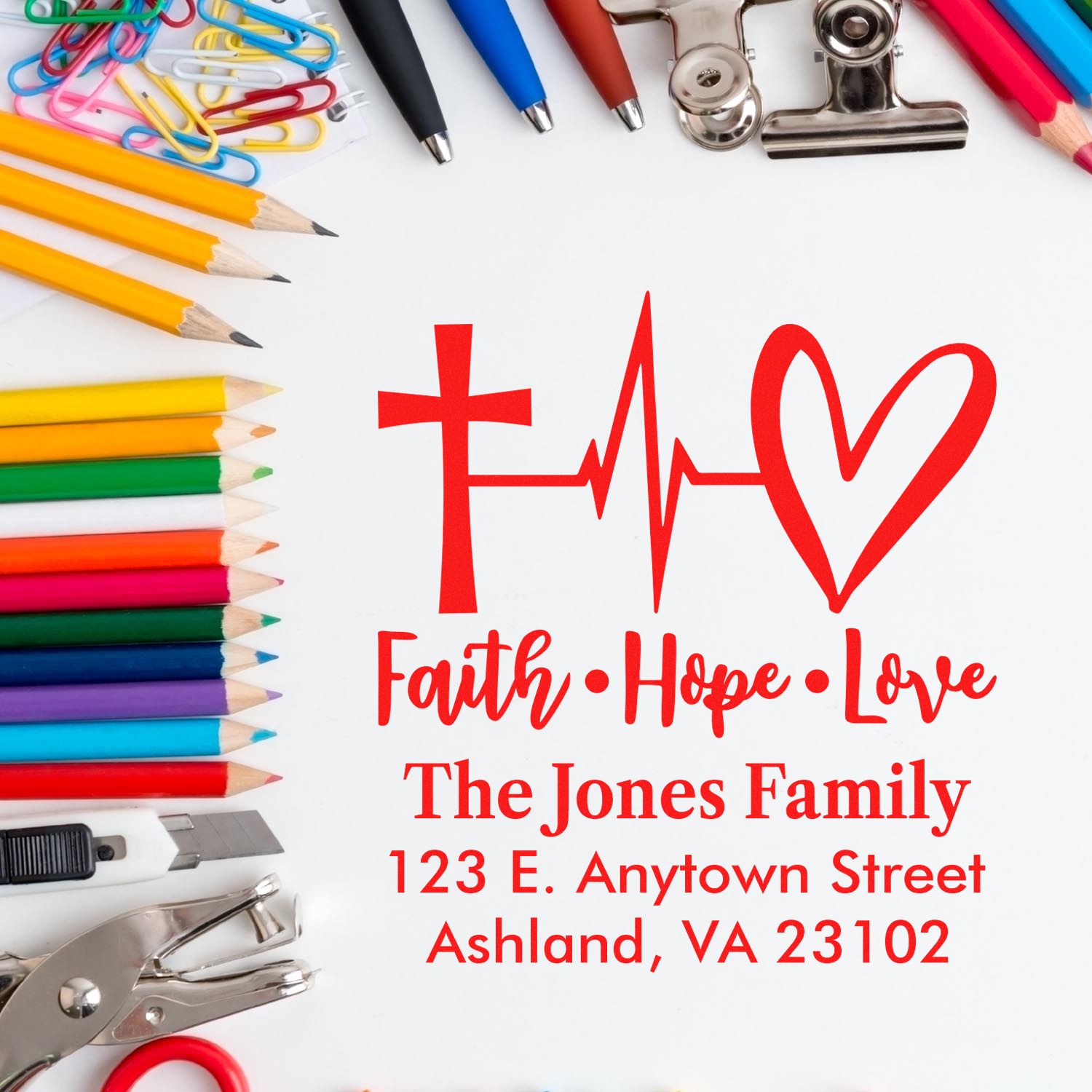 Custom rubber stamp design with Faith Hope Love, The Jones Family, and address, surrounded by pencils and office supplies.