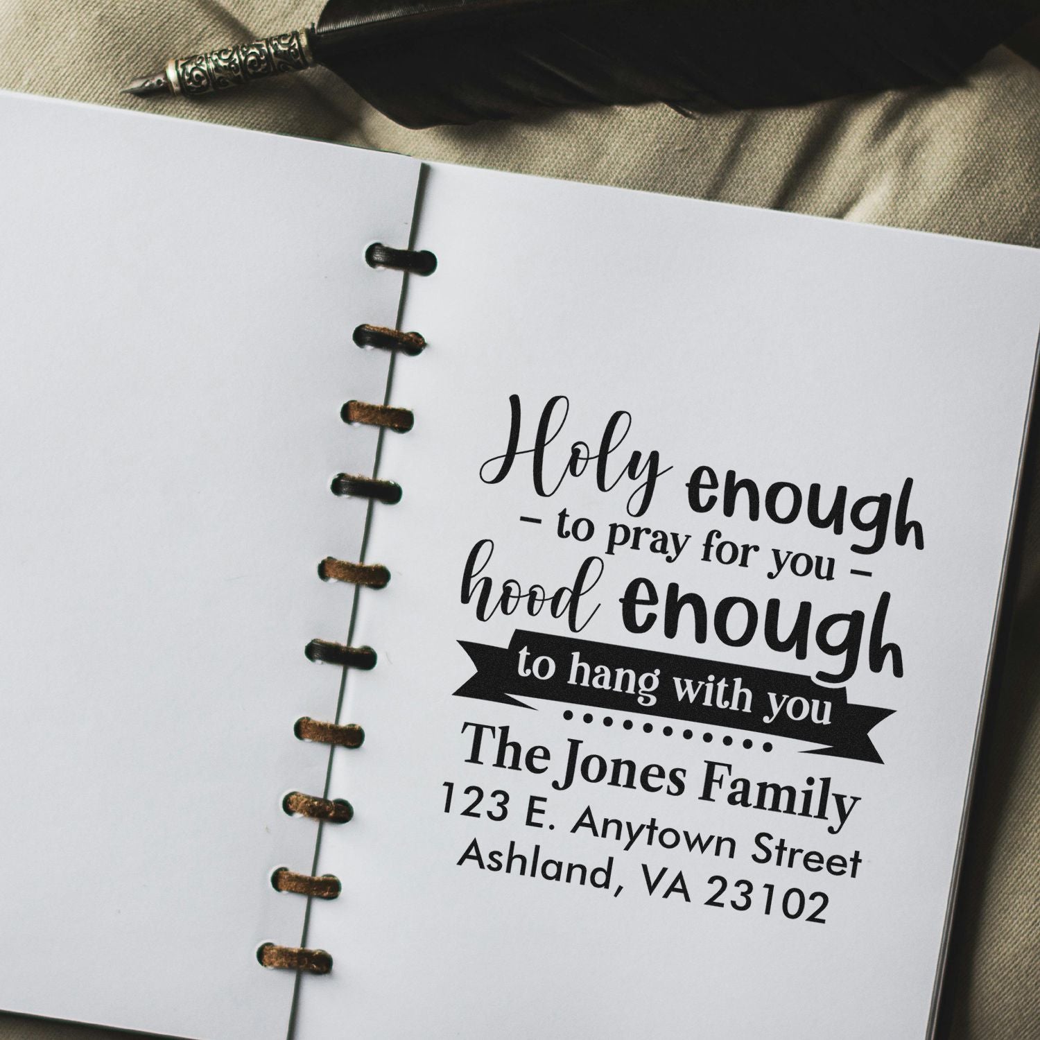 Custom rubber stamp impression with faith quote and family address in a notebook journal