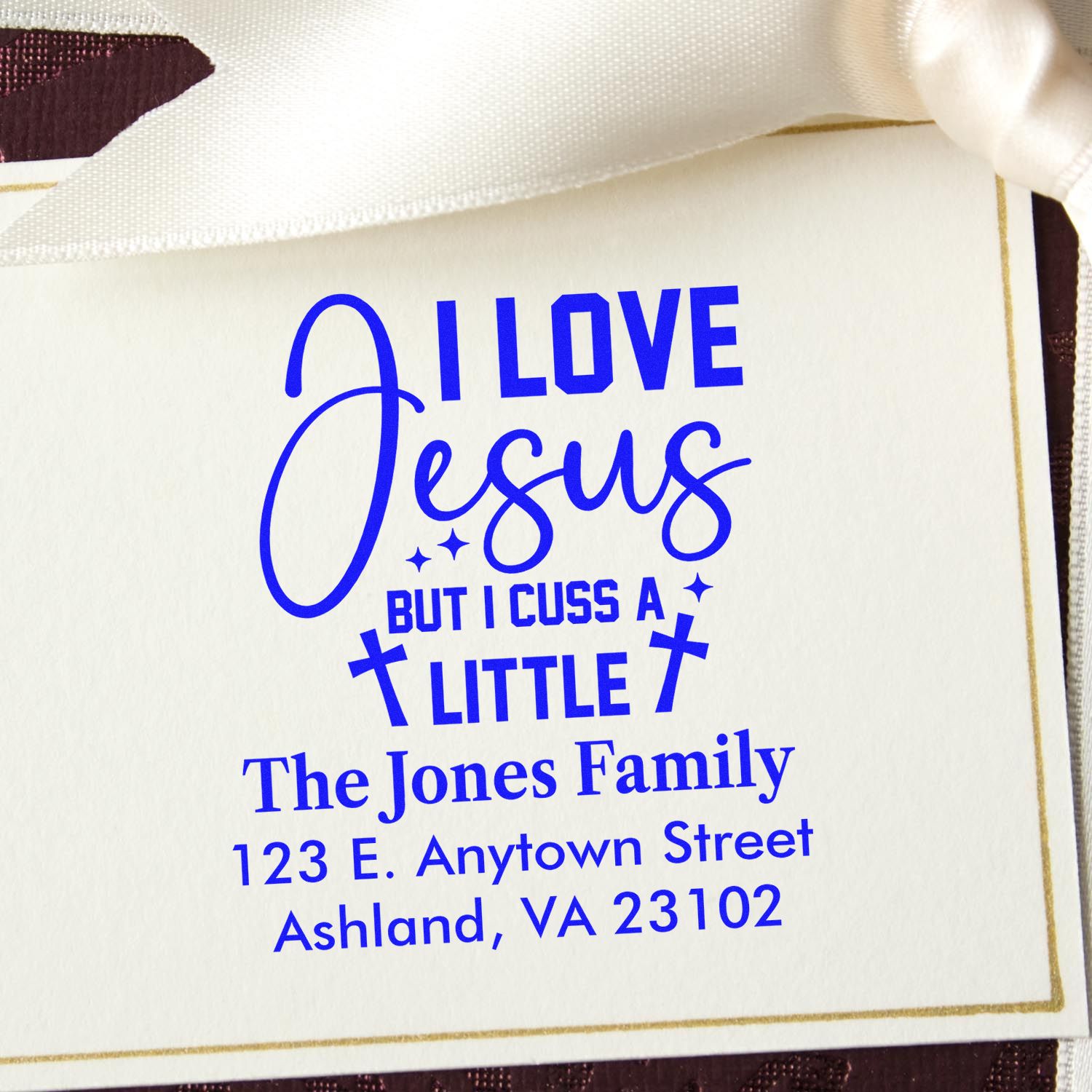 Personalized custom rubber stamp impression with I Love Jesus But I Cuss A Little and The Jones Family return address in blue ink.