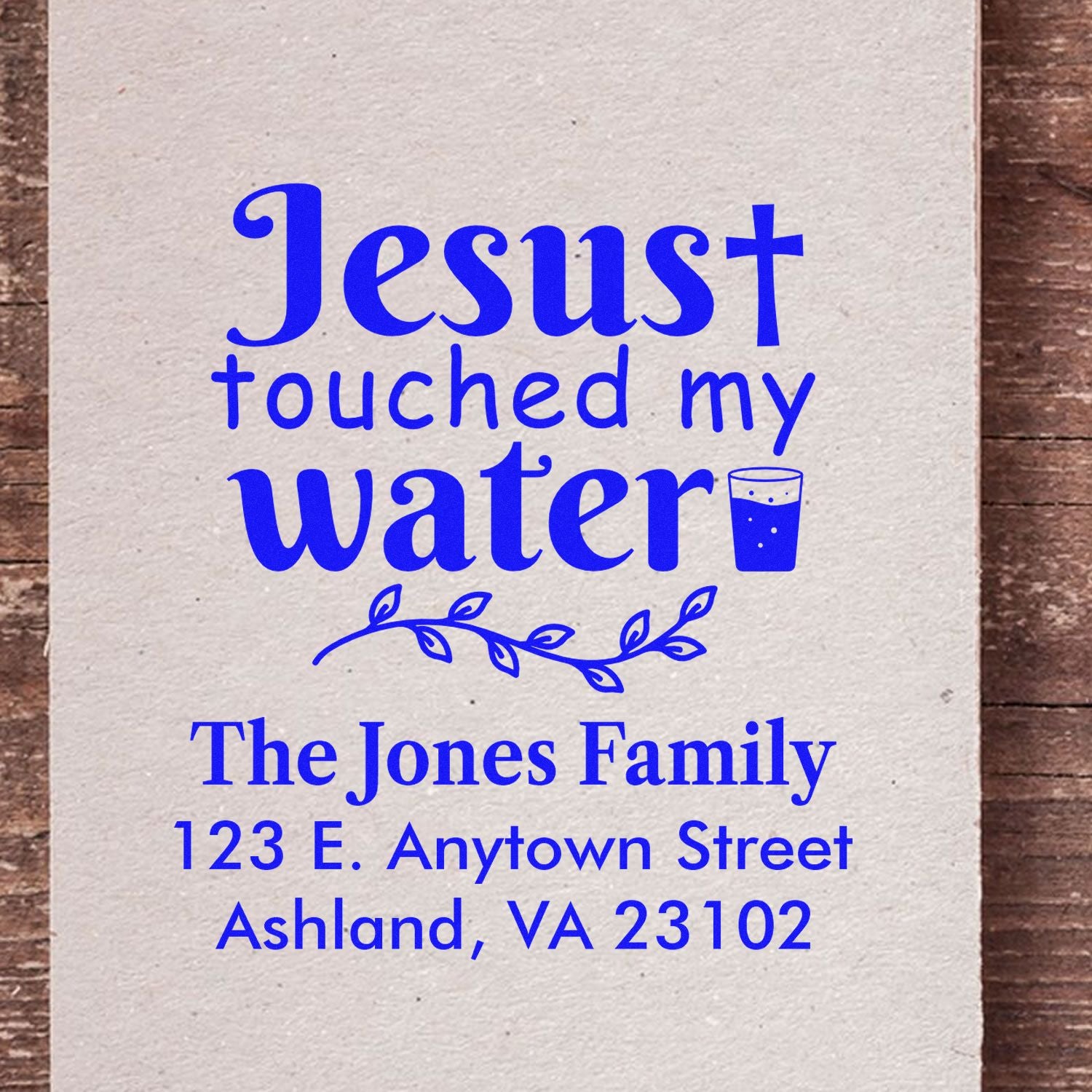 Custom rubber stamp design with Jesus touched my water, family name, and return address for personalized Christian gifts.