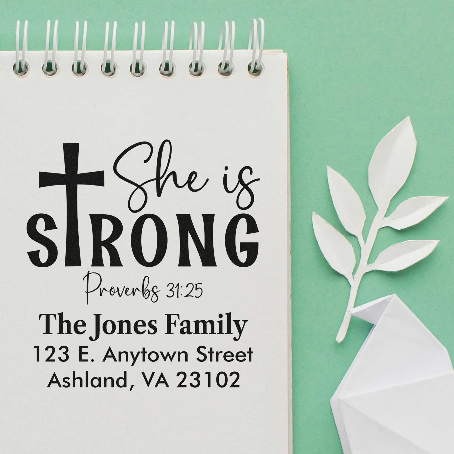 Personalized Christian rubber stamp with cross, She is strong Proverbs 31:25, and family address for custom mailings.