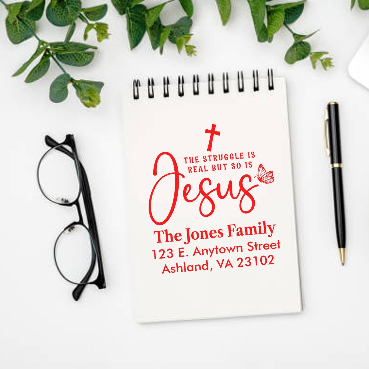 Personalized Christian return address rubber stamp with Jesus quote for The Jones Family, shown on a notebook mockup.