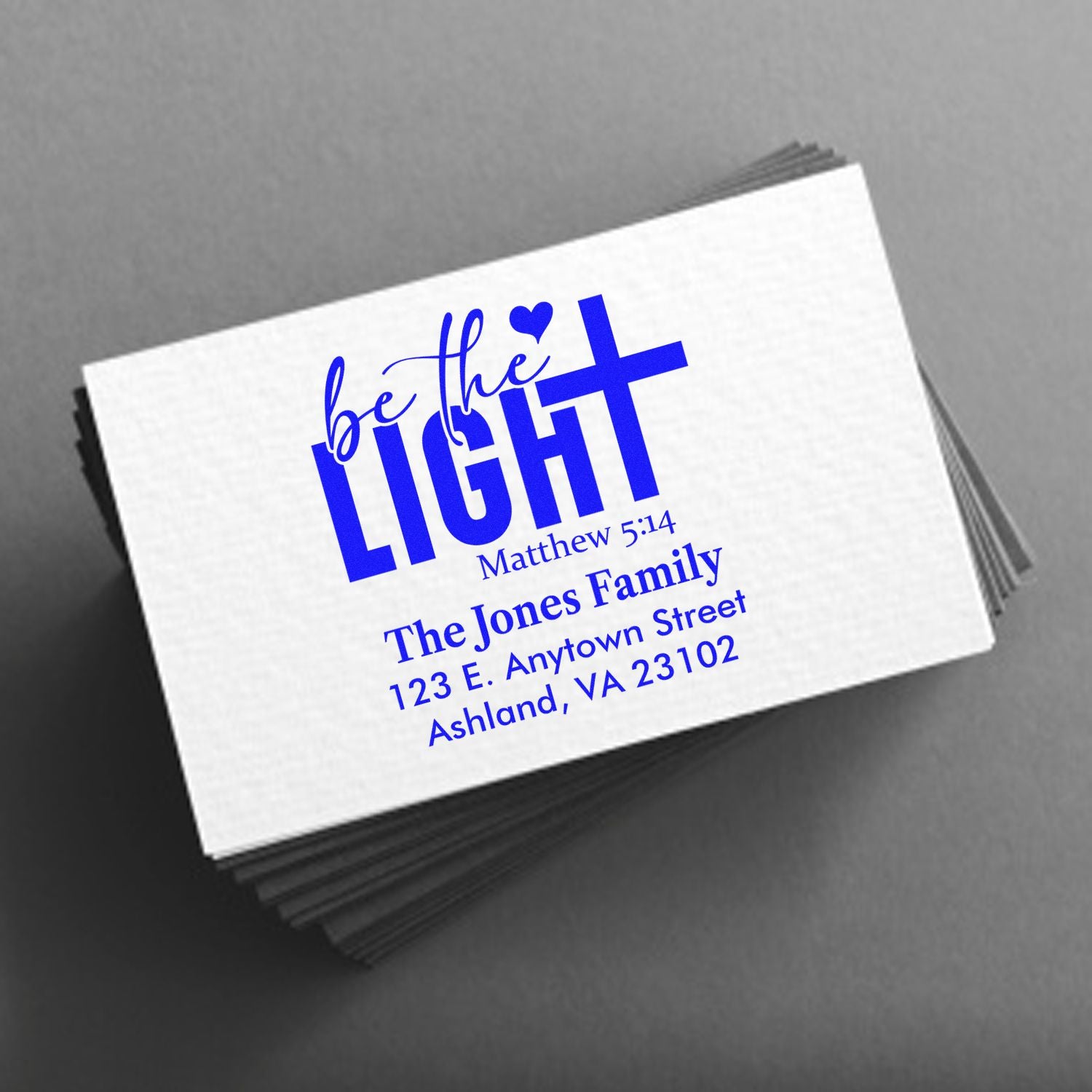 Custom rubber stamp design reading Be the Light Matthew 5:14 with family name and return address.