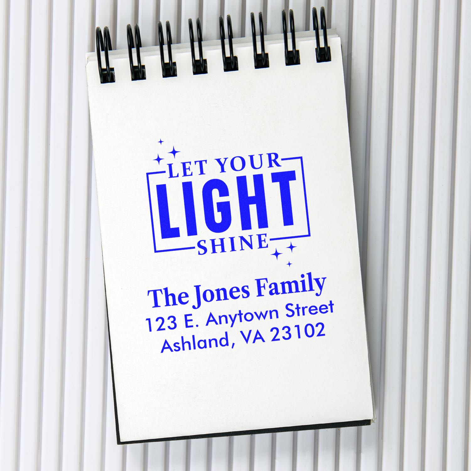 Custom rubber stamp design with Let Your Light Shine and return address for personalized mailing.