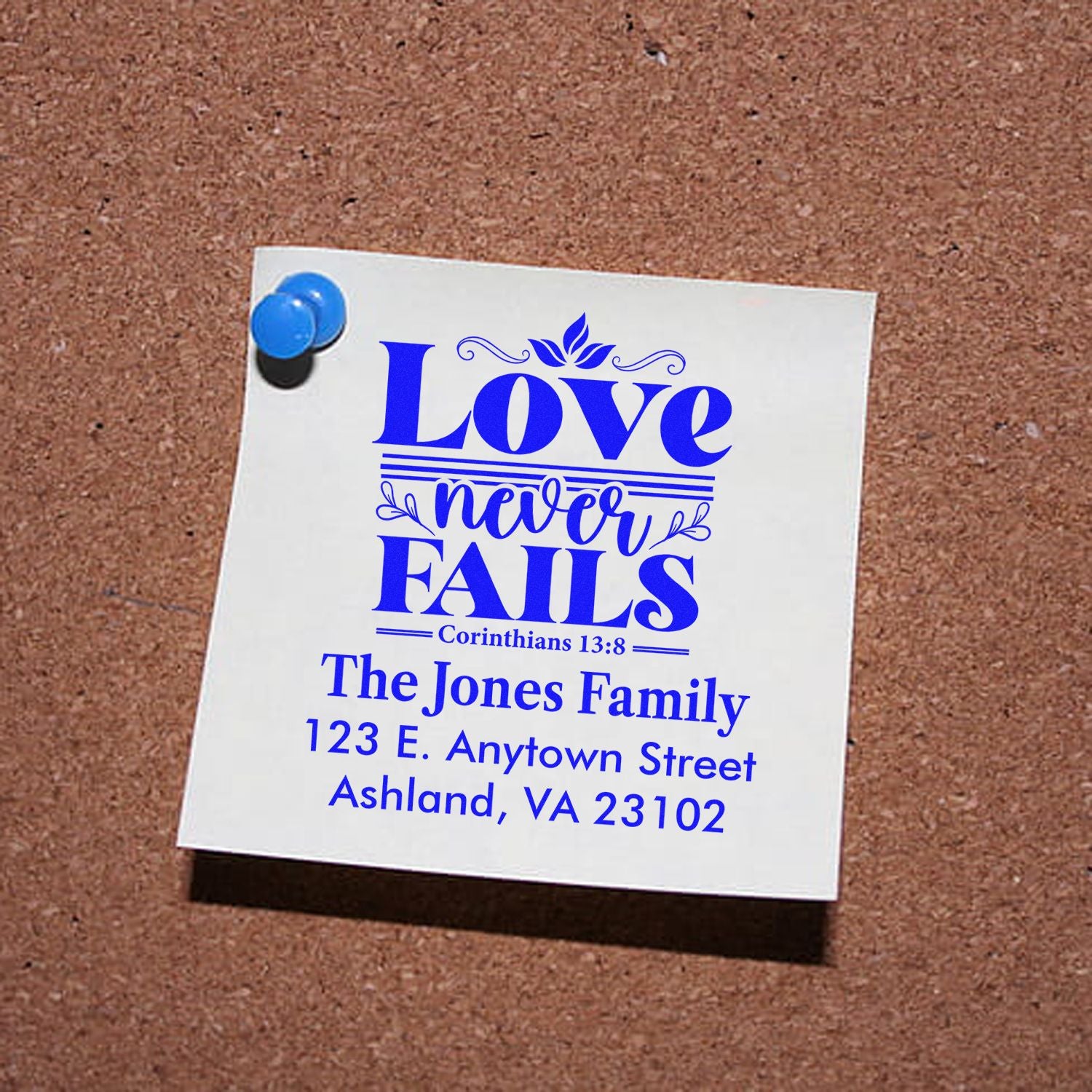 Custom rubber stamp proof with Love never fails Bible verse, family name, and address for personalized return mail.